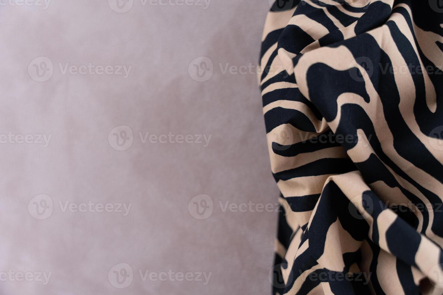 Zebra print fabric with beige and black pattern on soft background, close-up with copy space photo