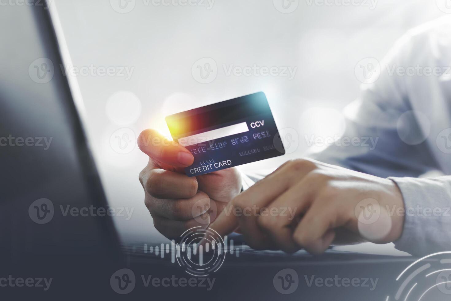 Asian man showing credit card for laptop payment for online shopping at home with copy space. E-payment technology, electronic transactions or mobile phone financial application concept photo