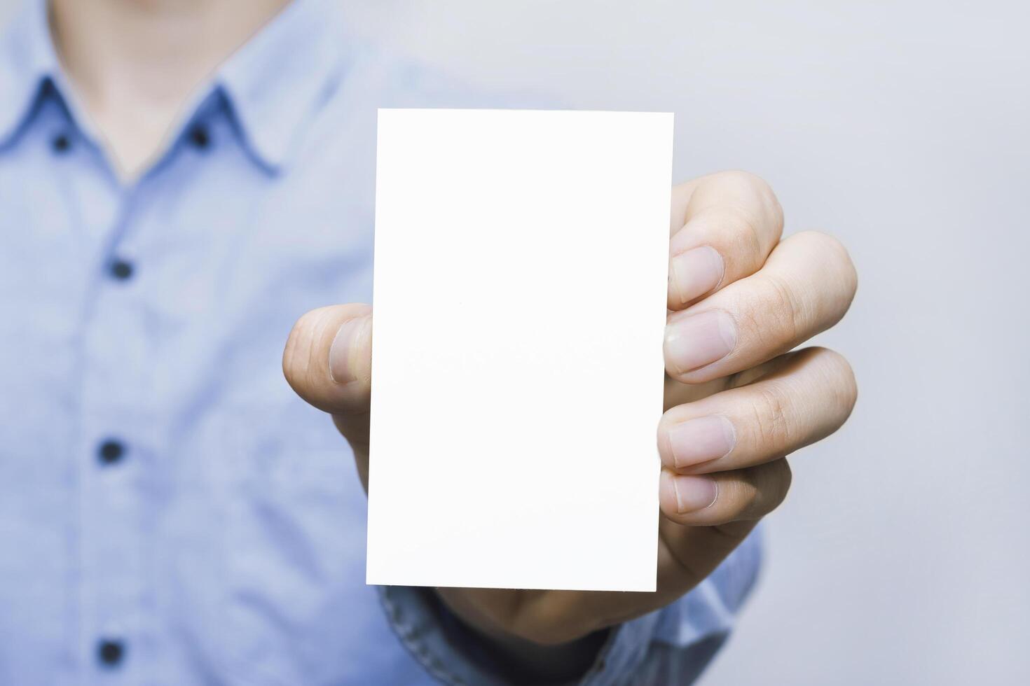 White business card in male hand with copyspace. Ideal for modern branding, message, contact, networking, design, corporate promotion, clean layout, marketing material, and identity. photo