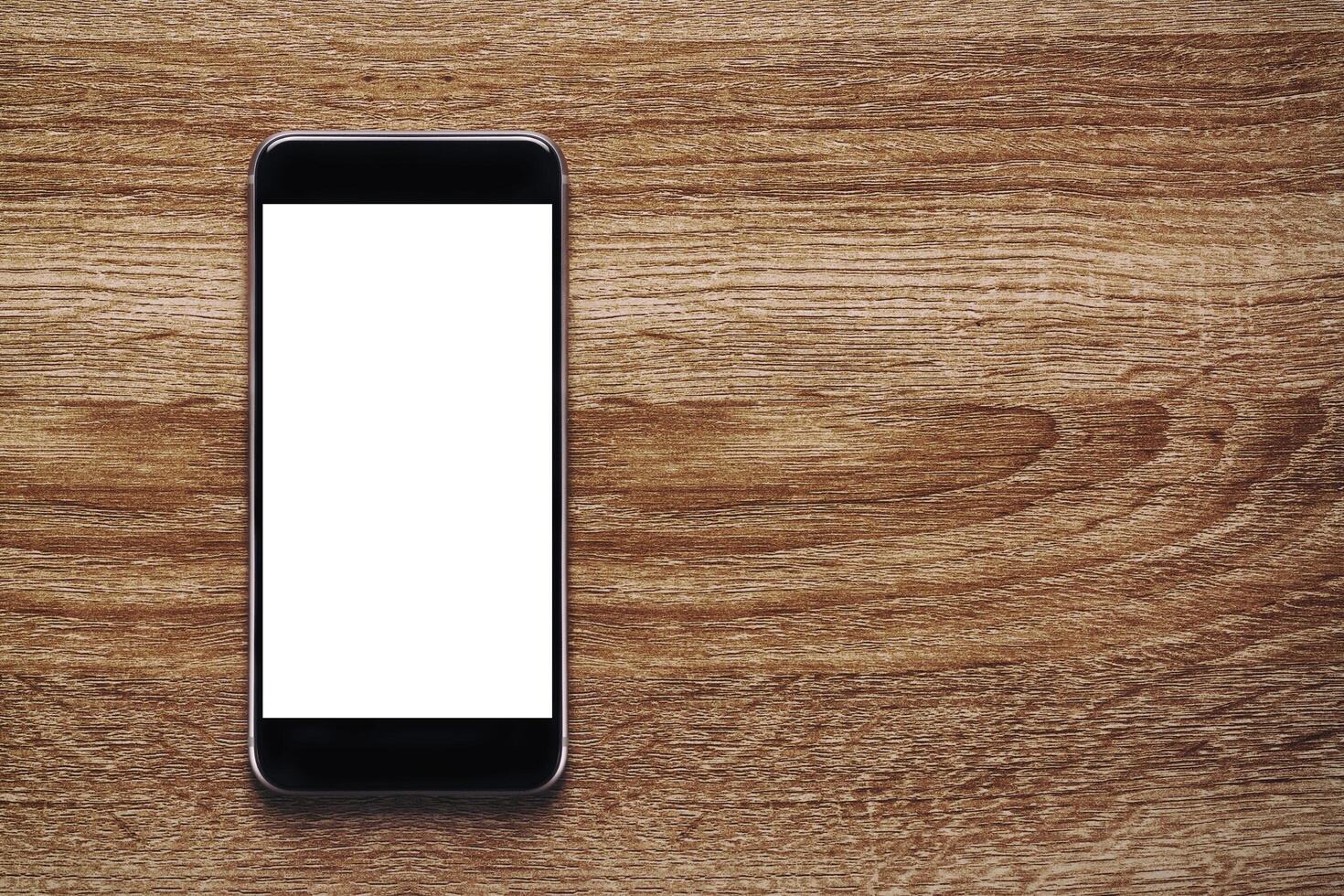 Smartphone with Mockup image white screen On Wooden Table With beautiful patterns, copy space for adding content. Smartphone concept and lifestyle, clipping path photo