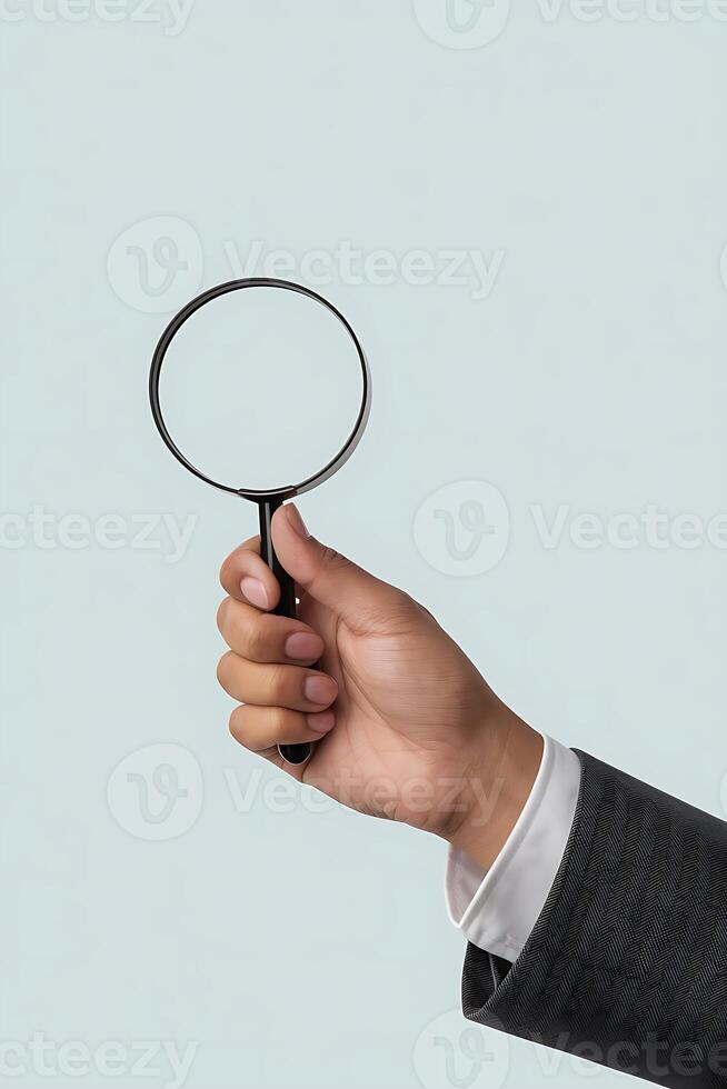 Close up of a business person holding a magnifying glass, looking for solutions photo