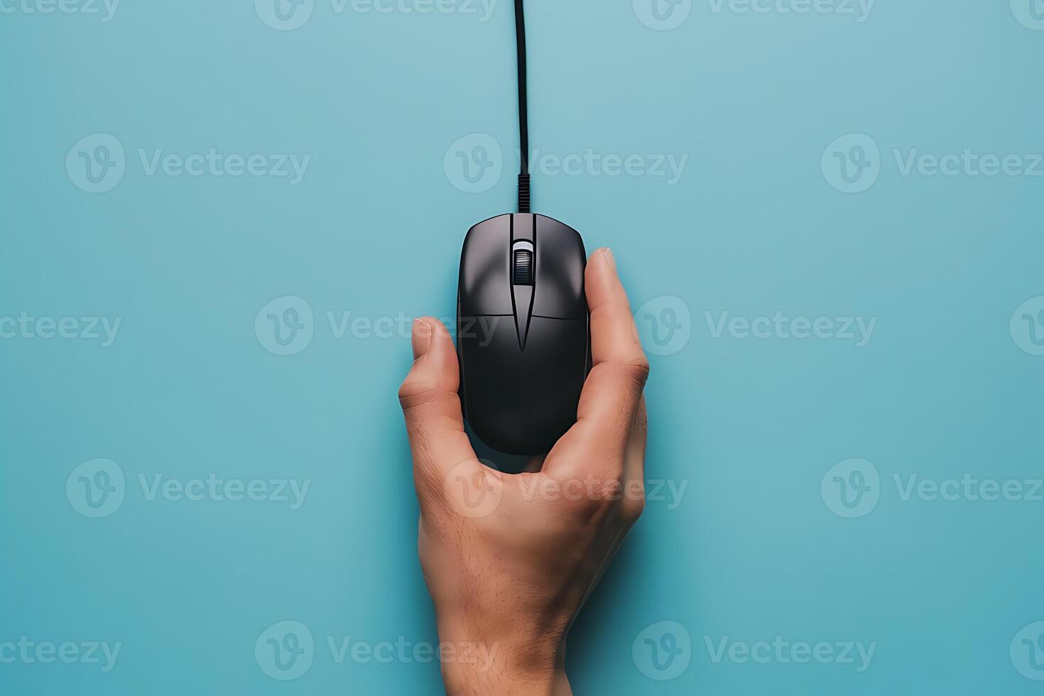 Hand holding computer mouse on blue background symbolizing technology photo