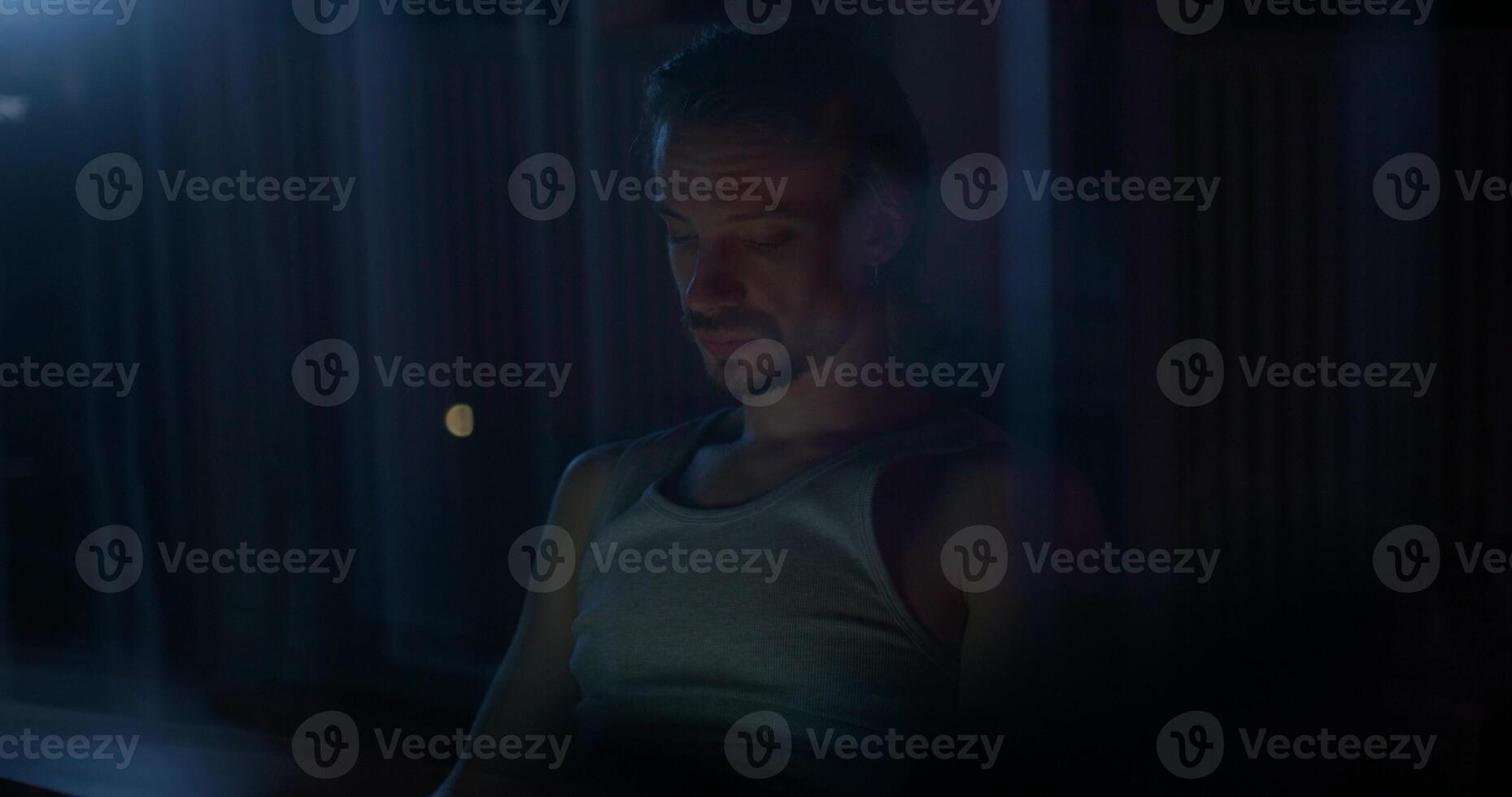 A man uses a laptop while sitting on the couch at night. photo