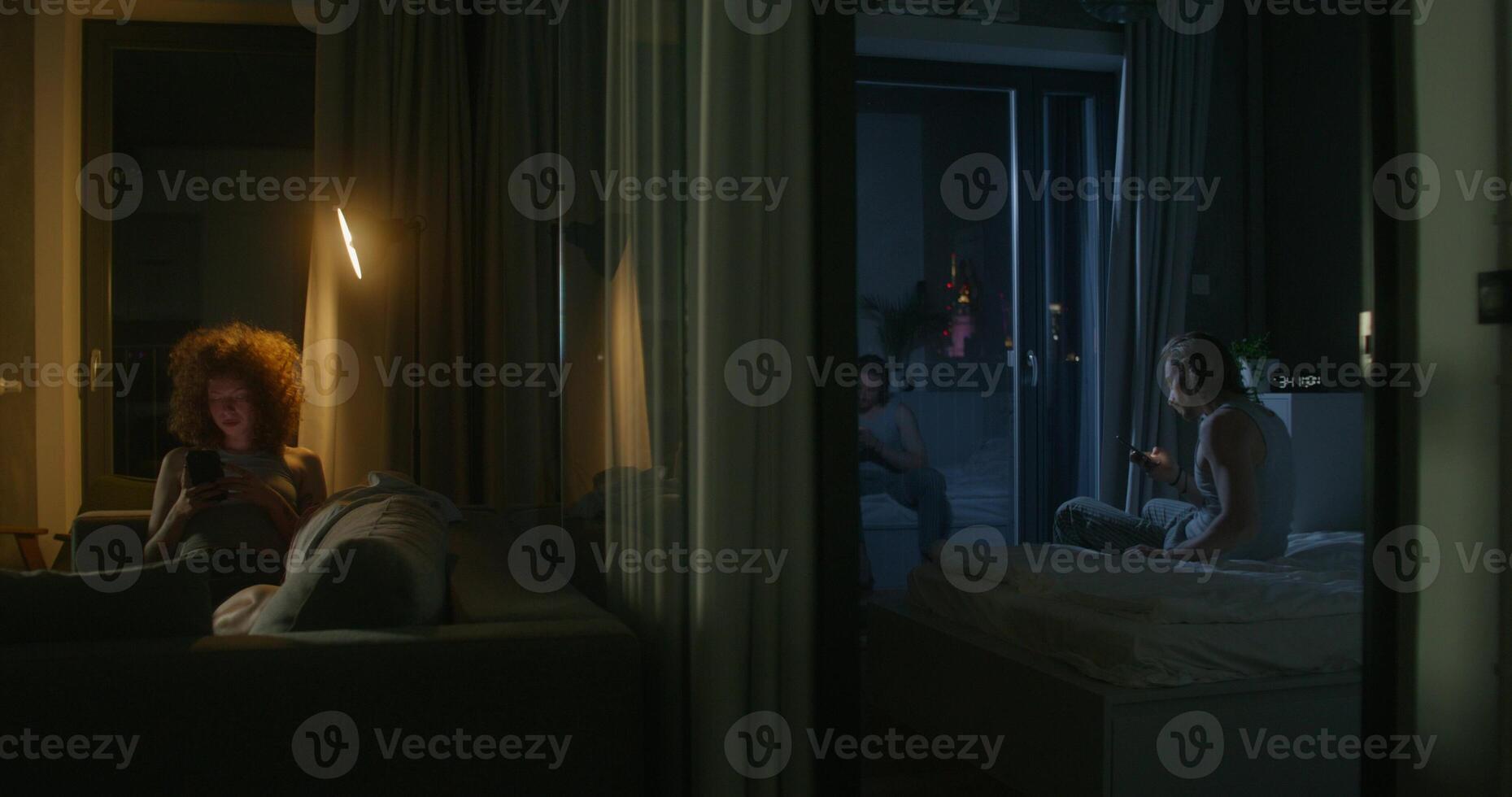 A man and a woman use mobile phones at night. They are sitting in different rooms. Online correspondence. Insomnia photo