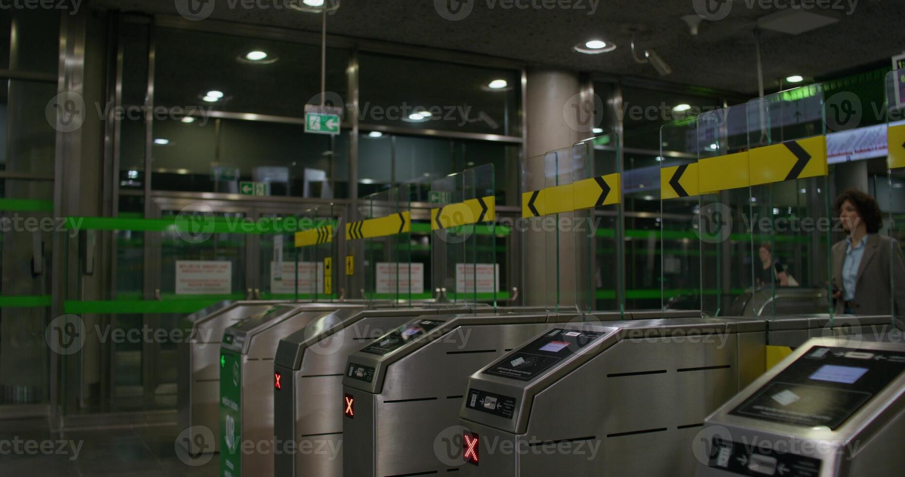 A stylish woman leaves the subway, she passes through the terminal. She holds a mobile phone in her hand photo