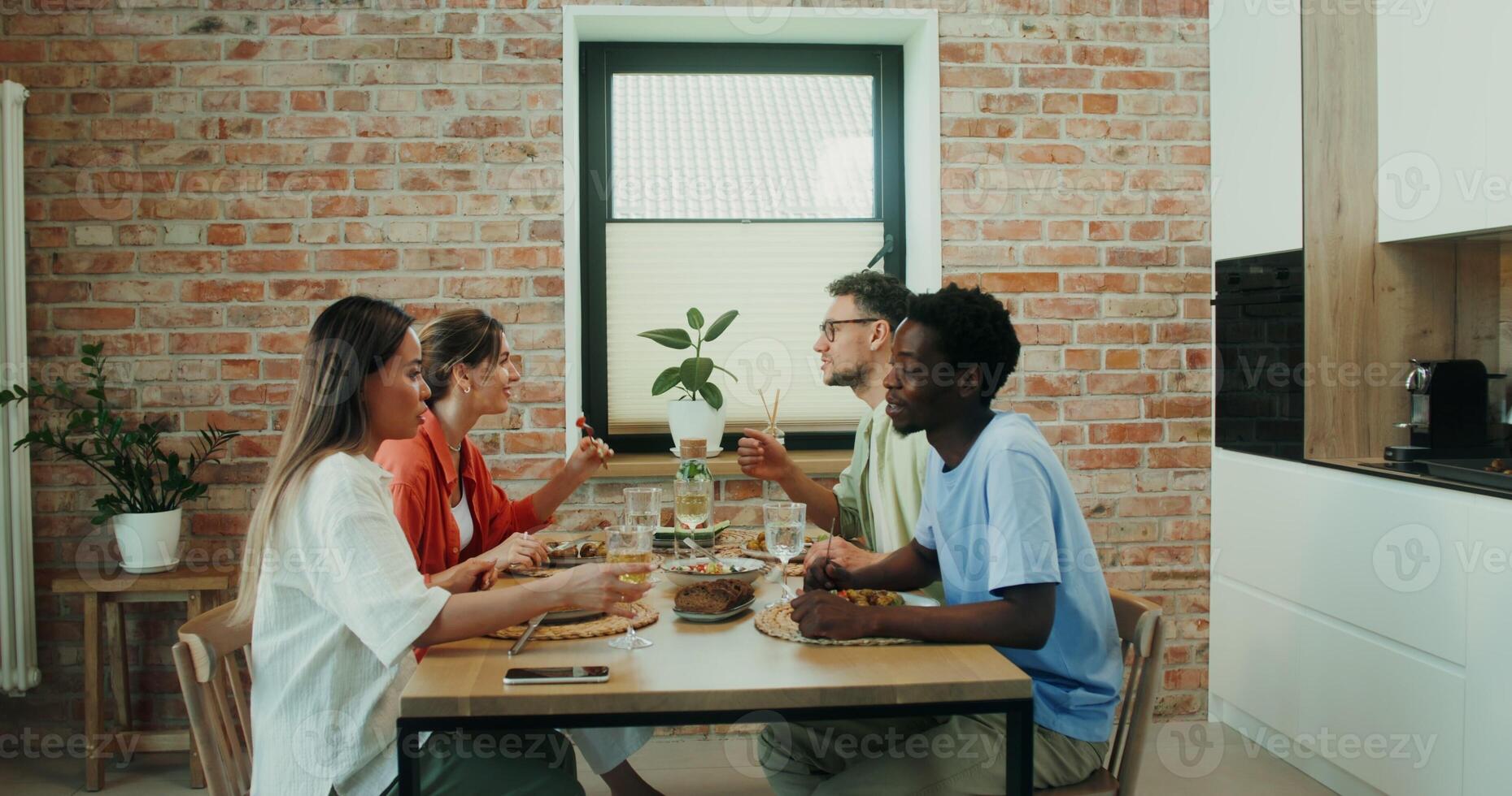 A group of young people talking while having lunch together at home during vacation photo
