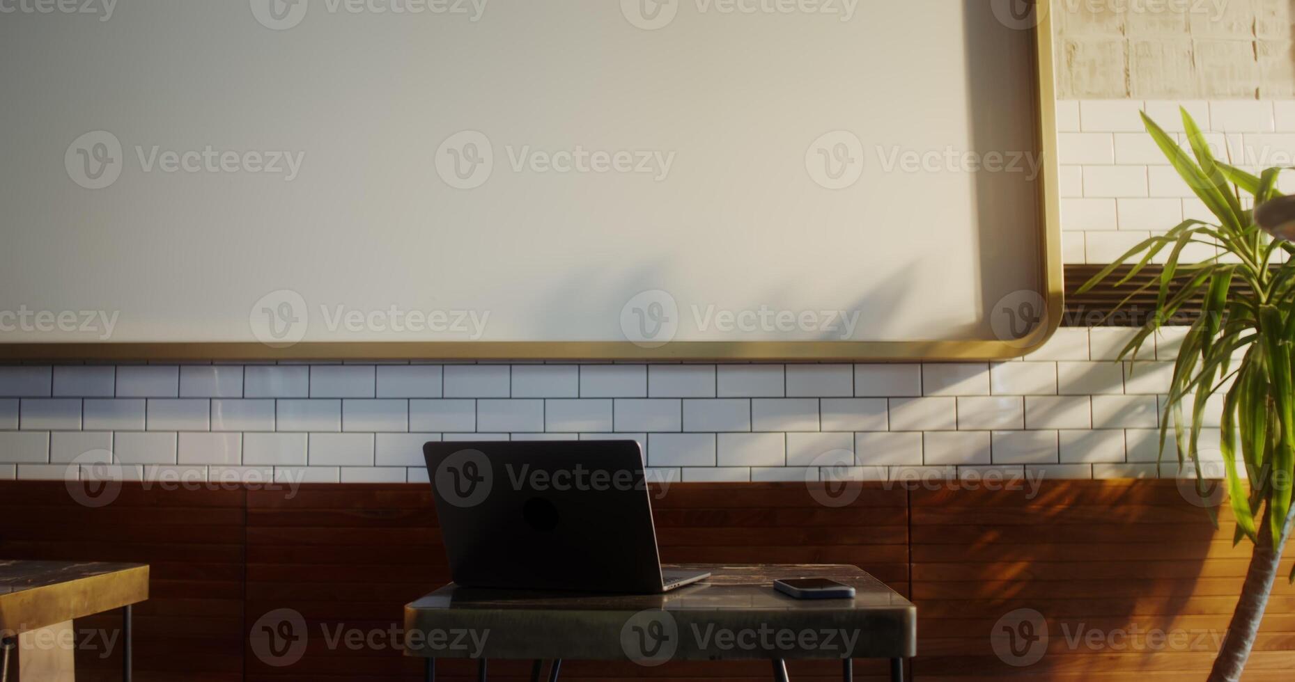 A man with a cup of coffee and a donut in his hands sits down at a table in a cafe opposite an open laptop - laptop photo