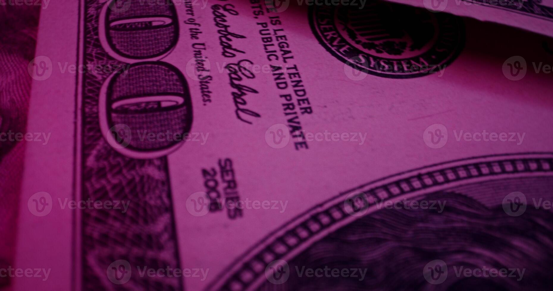 Hundred dollar bills are scattered on the table. An overview of the details of paper money in ultraviolet light - overview photo