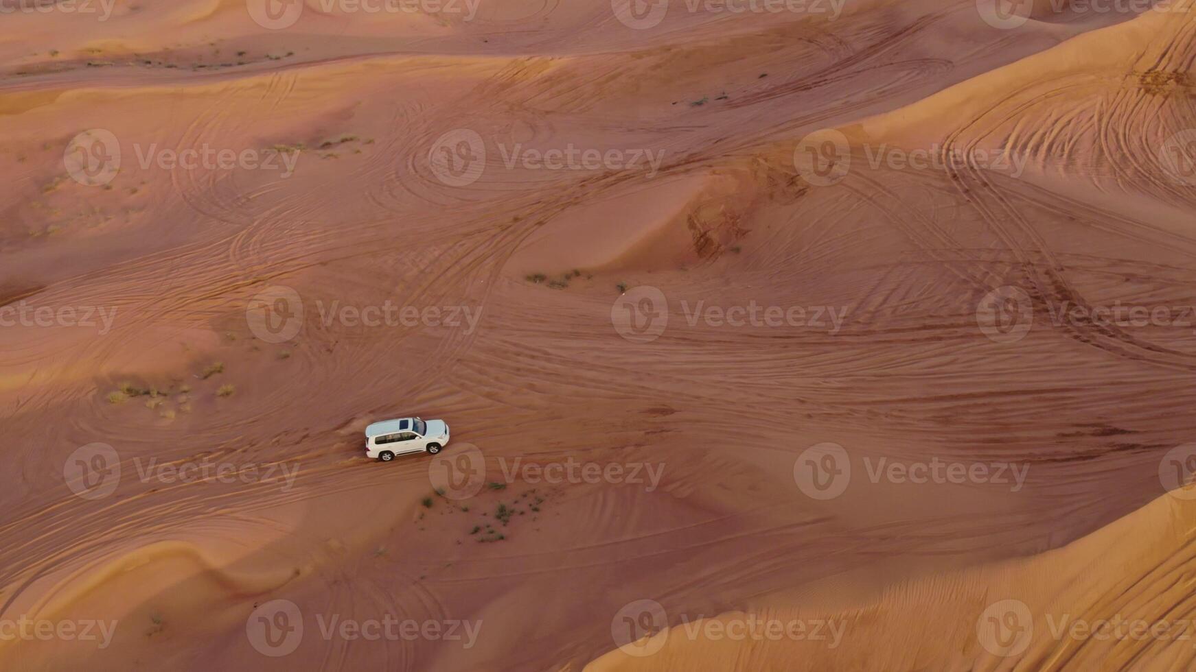 A bird's-eye view from a drone of car drifting among the sand dunes. Off-road driving in the desert - desert photo