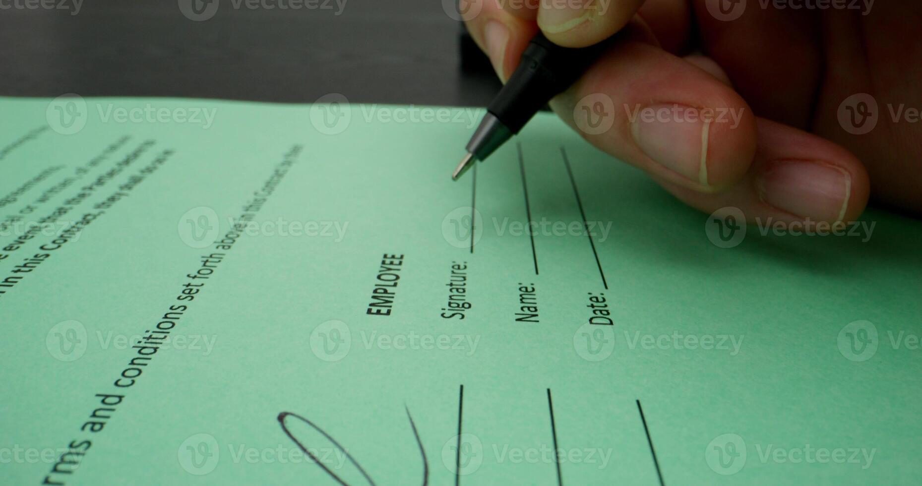 A man puts his signature on an employment contract, close-up of his signature, an unrecognizable person photo