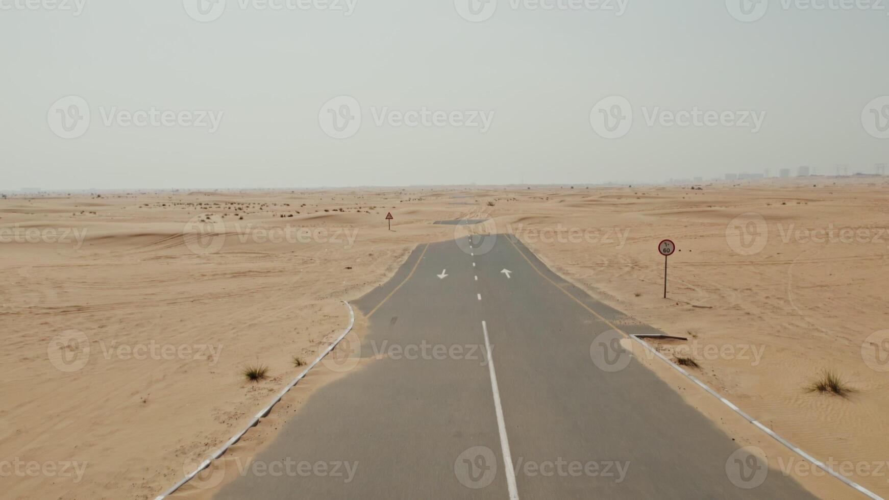 Drone view of an asphalt road in the middle of the desert, covered with sand photo