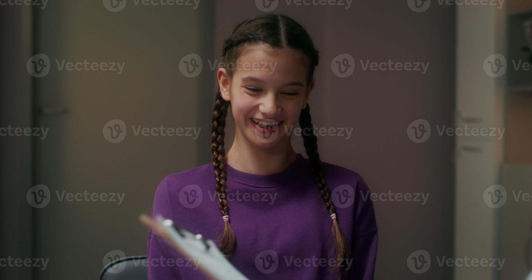 The doctor talks to the girl patient, finding out the symptoms of the disease and writes in a notebook, sitting in the medical office at the clinic photo