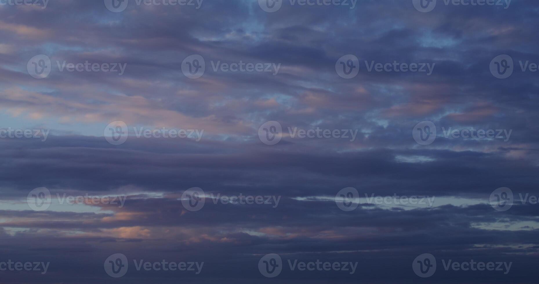Cloudy sky at sunset. Pink reflections on the clouds slowly floating across the sky over the sea. in 4k, red komodo photo