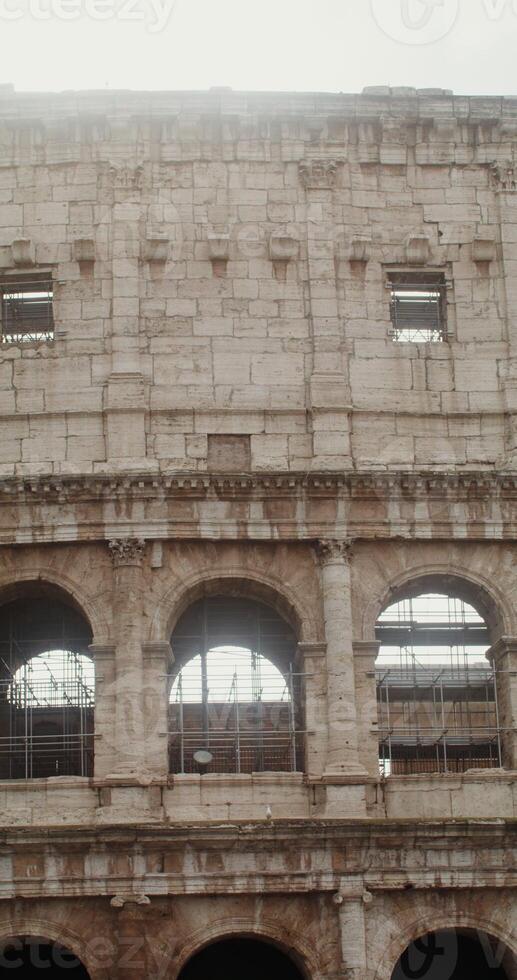 Close-up of the middle part of the Colosseum with arches and vaults on a sunny clear day, vertical . Italy Rome. in 4k, red komodo photo
