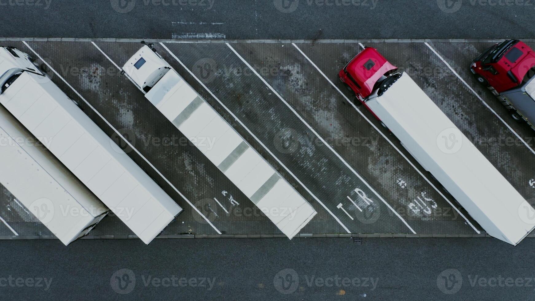 filming from a bird's eye view of the trucks parked in the parking lot. filming from a drone, top view - parked photo