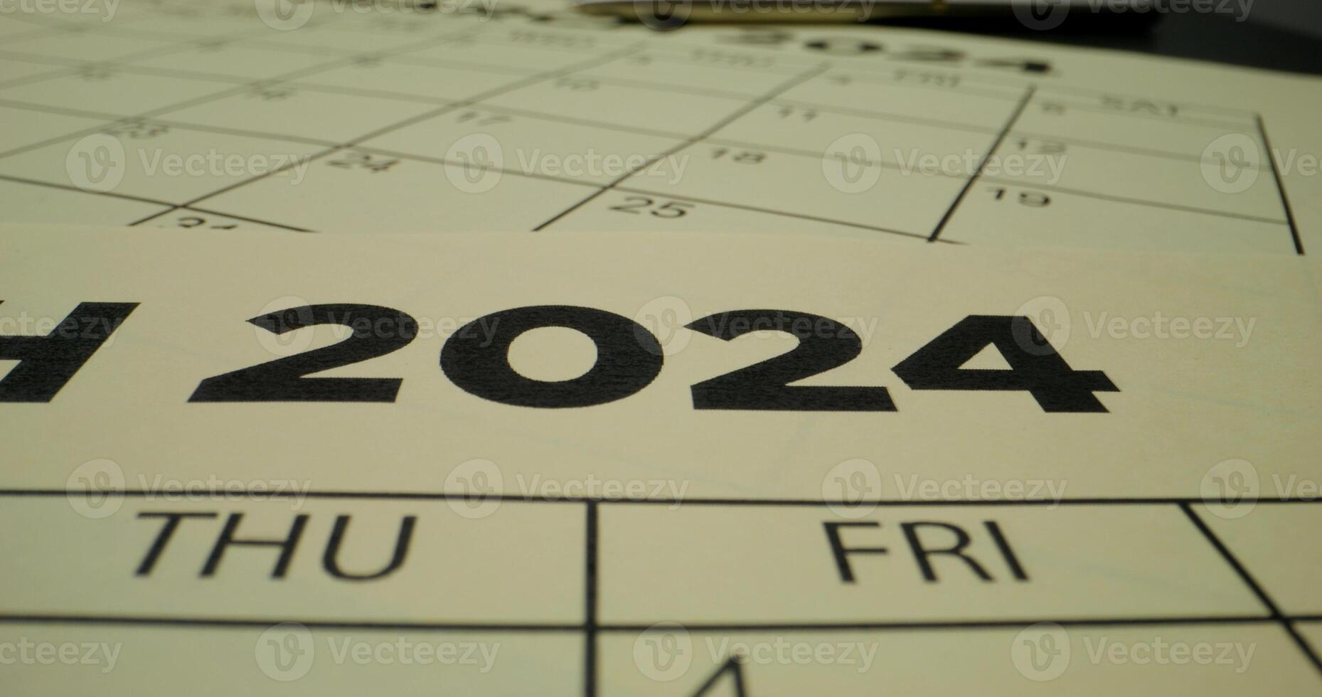 A person crosses out the year in the schedule table with a red marker. Close-up of the marker, an unrecognizable person photo