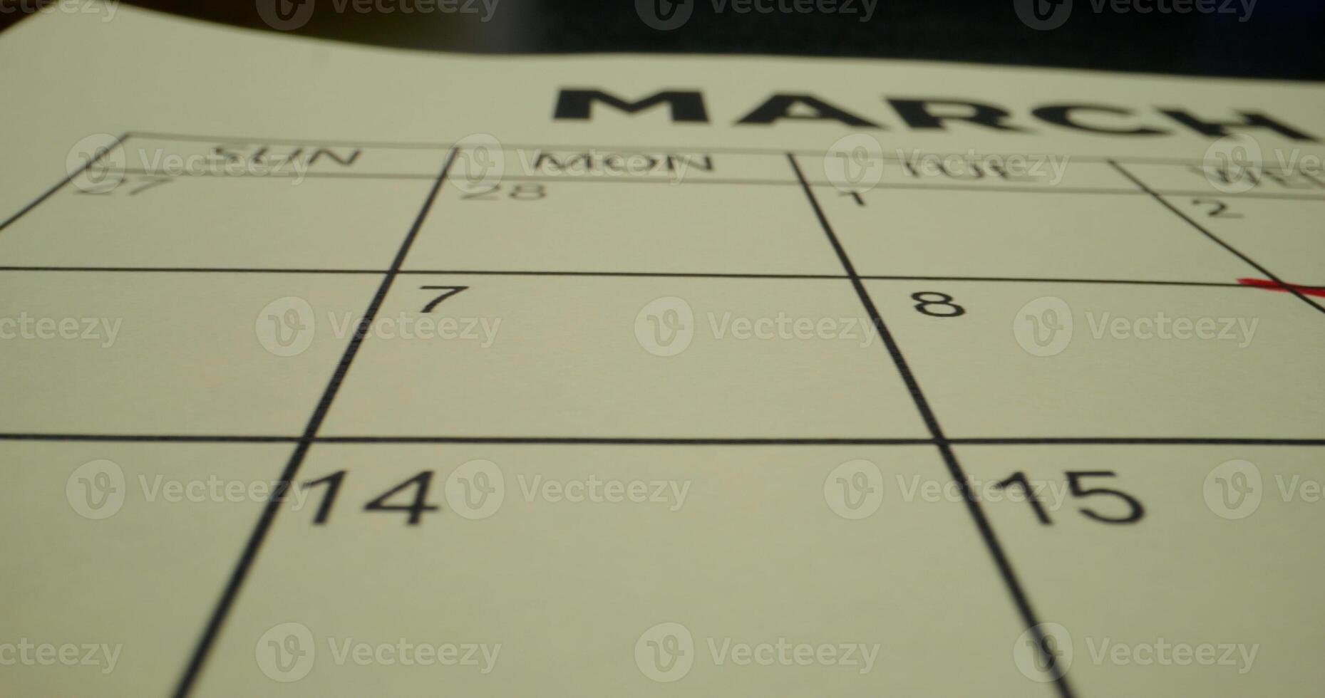 A schedule table with days of the week and numbers. One of the dates is crossed out with a red cross. Close-up - schedule photo