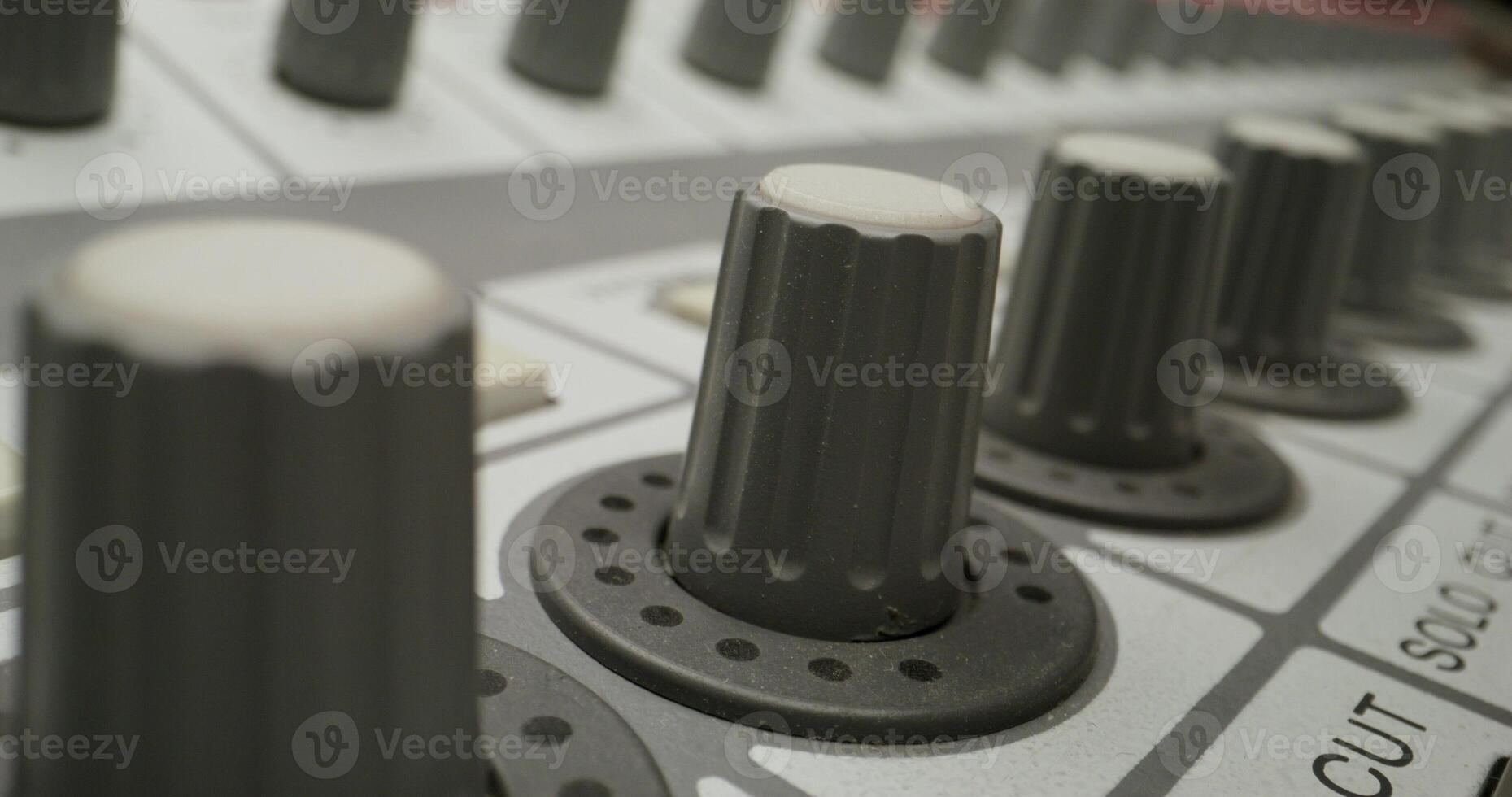 A man controls a mixing console while recording audio in the studio. Close-up of his hand, an unrecognizable person - console photo