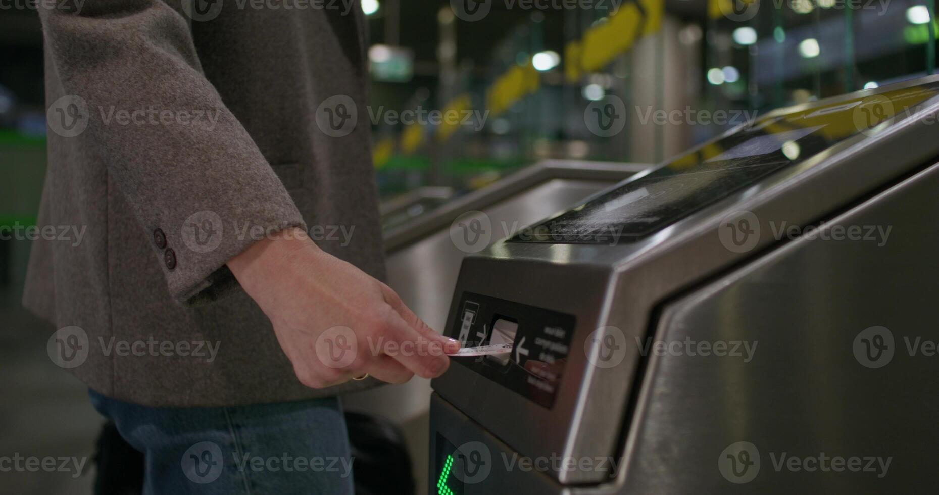 A woman inserts a card into a subway terminal and passes through. close-up of her hand, an unrecognizable person photo