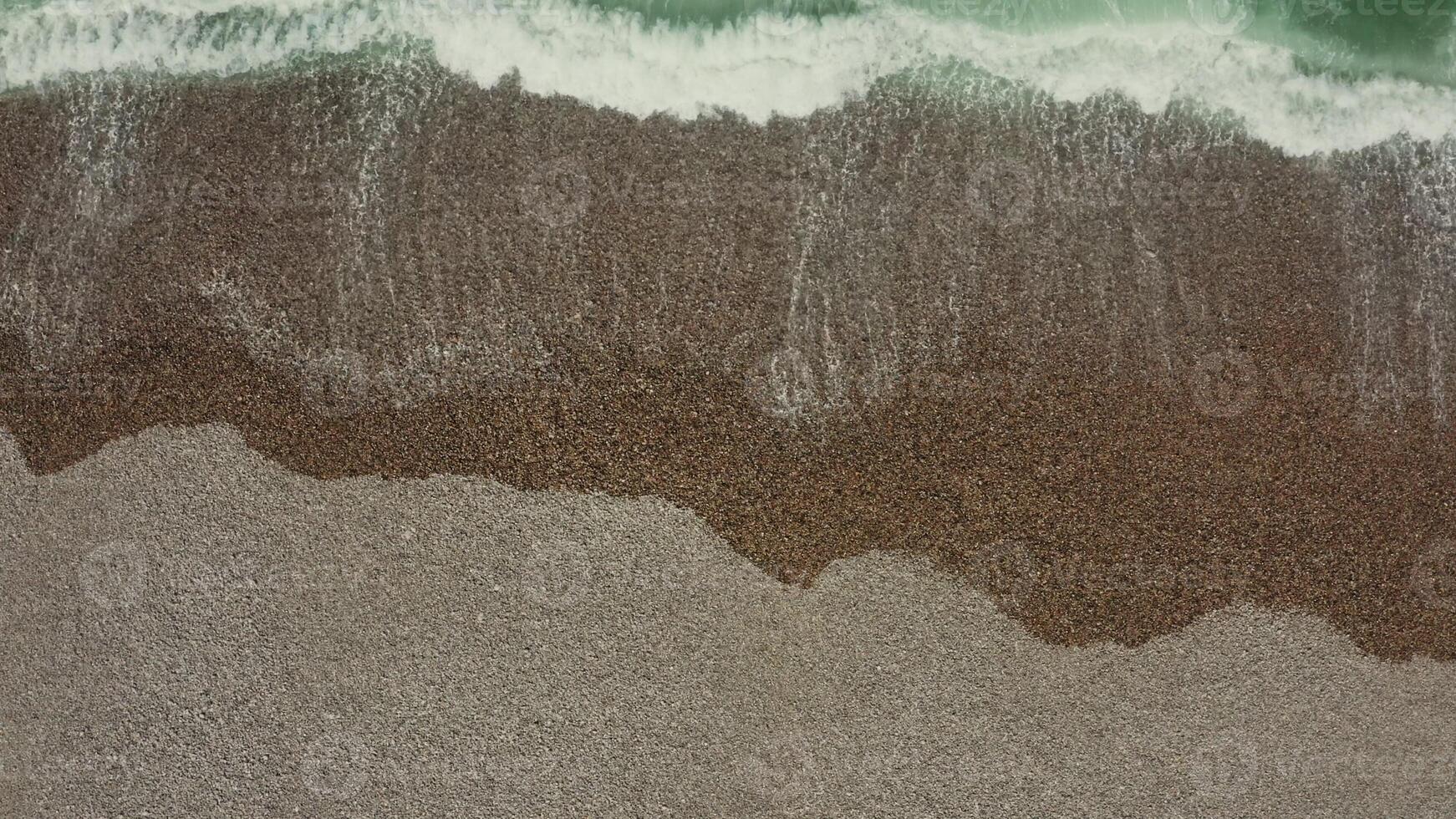 Top view of the sea shore. Emerald water washes the pebbly shore, leaving foamy patterns, drone . - pebbly photo
