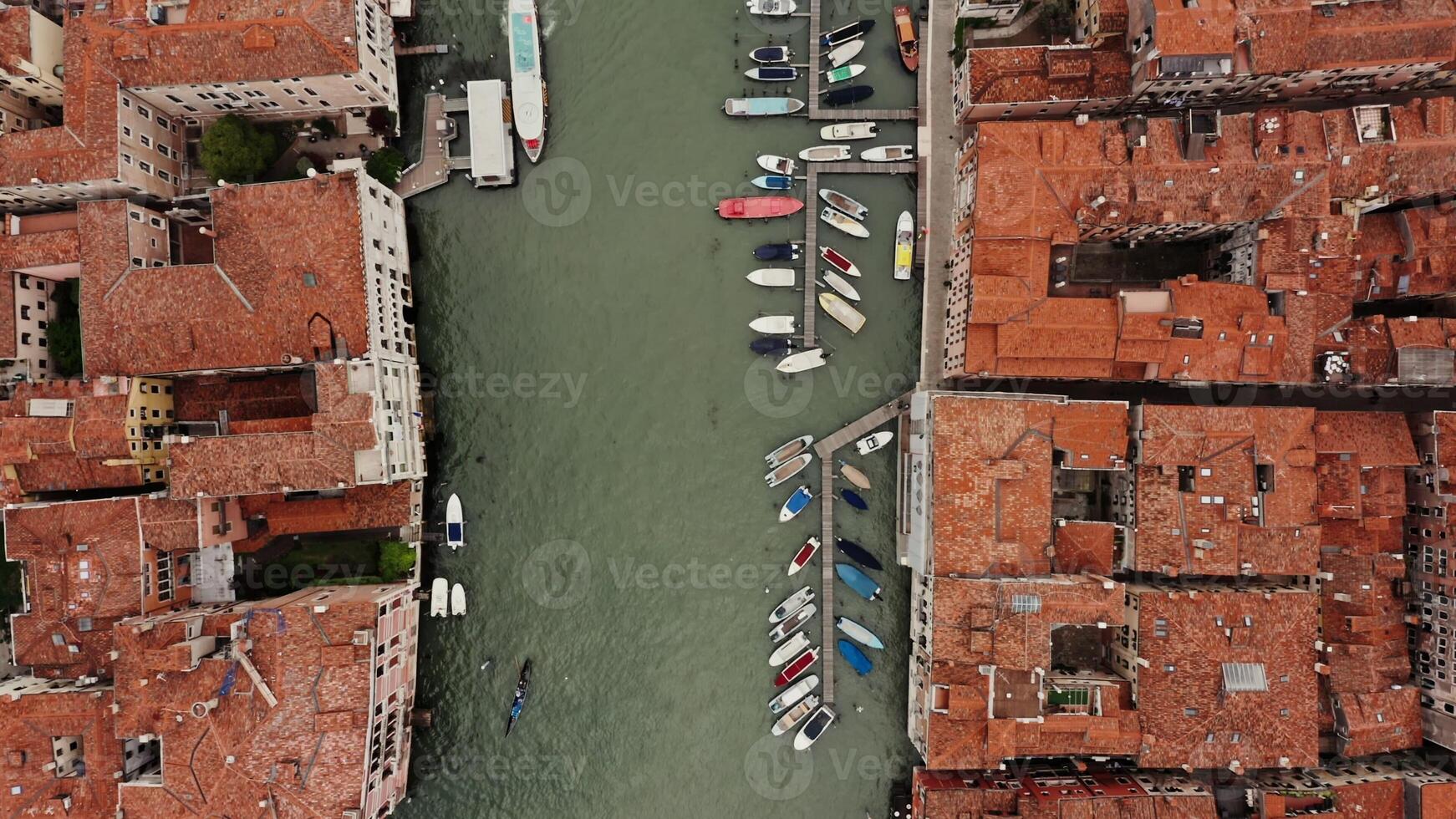 Top view of the Grand Canal with empty gondolas tied to the pier. Traditional houses on both sides of the canal, drone footage on a sunny day. Venice, Italy photo