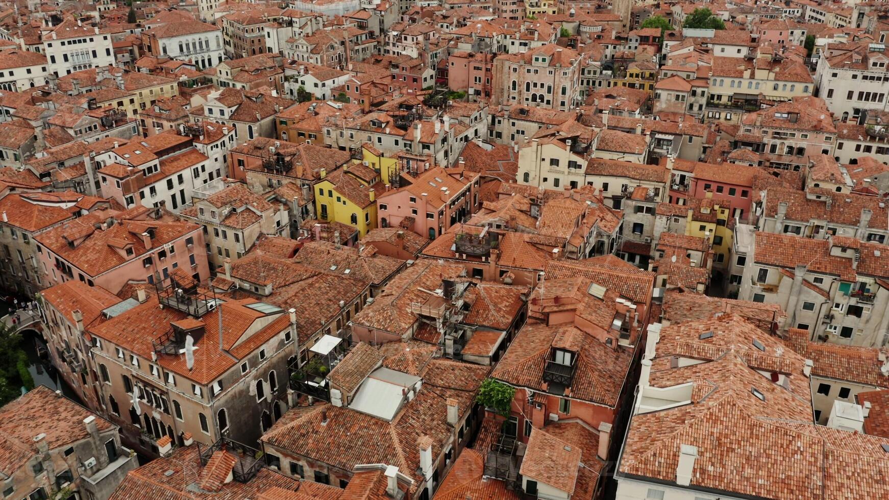 The drone flies over the orange rooftops of traditional Venetian houses. Narrow water channels instead of streets, aerial view, Italy - traditional photo