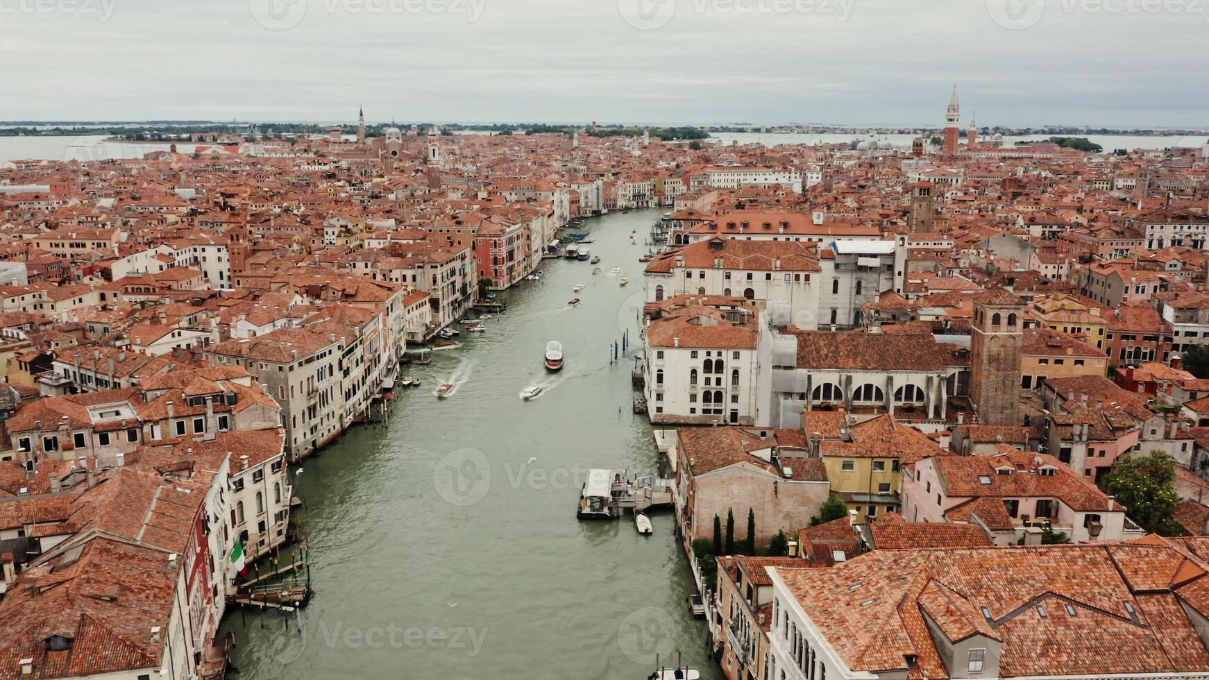 Panoramic drone footage of a traditional Italian city on the water, with the Grand Canal among orange-roofed houses. Venice, Italy, on a sunny day - traditional photo