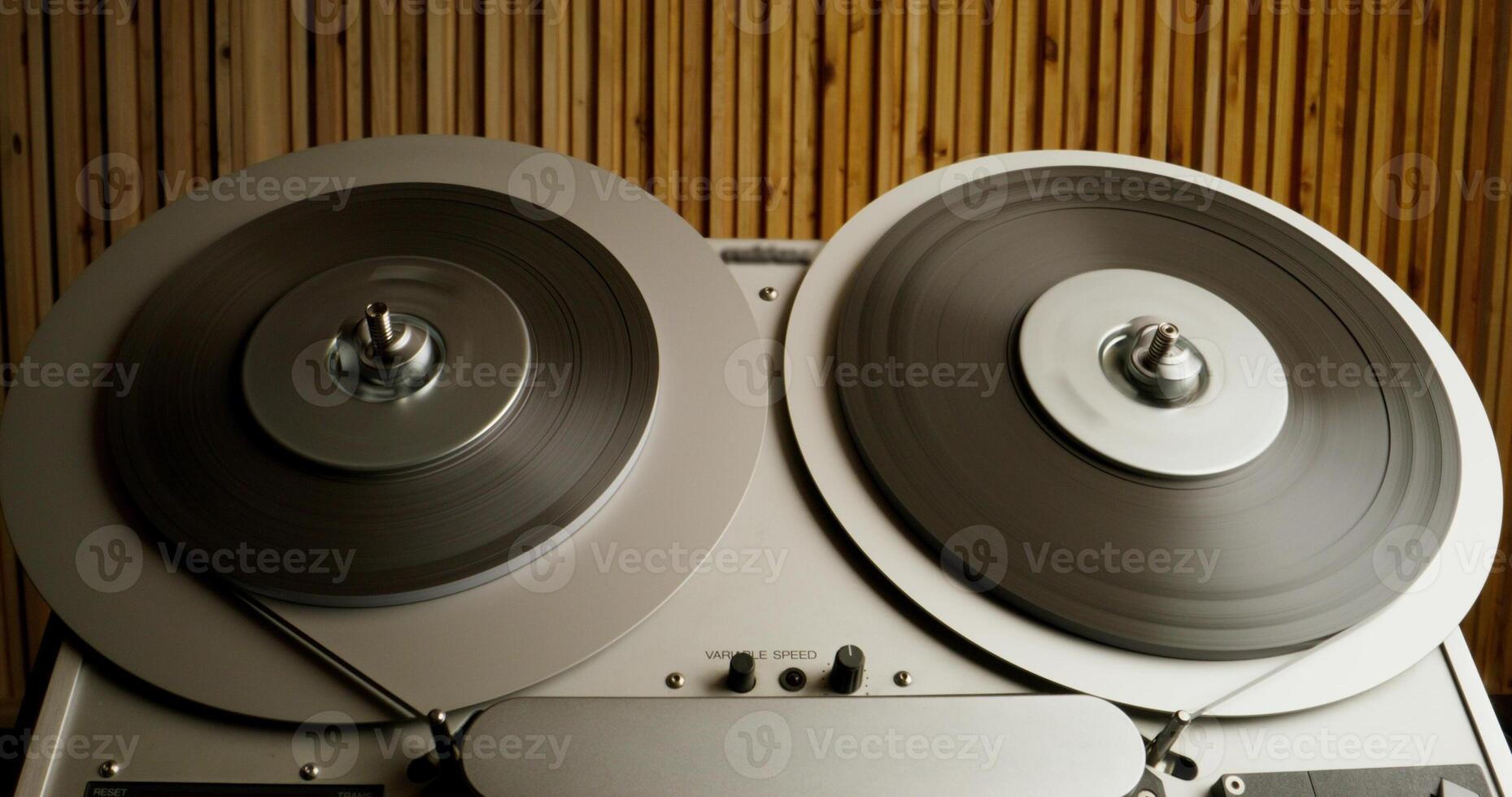 Sound recording on a tape recorder in a recording studio. Fast movement of the magnetic tape, close-up - movement photo