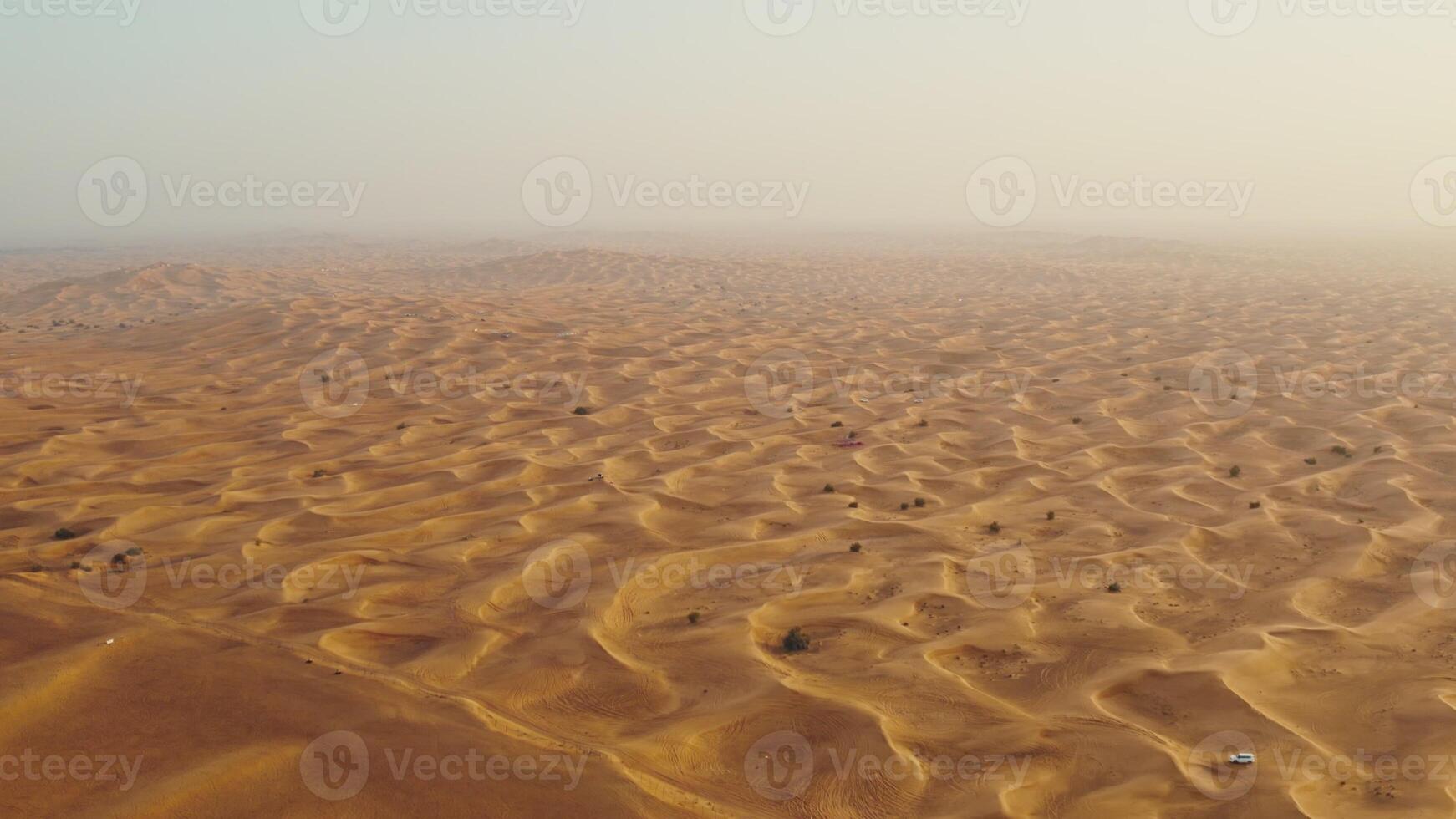 Drone view of sand dunes with sand merging with the sky. Driving off-road in a lifeless desert - lifeless photo