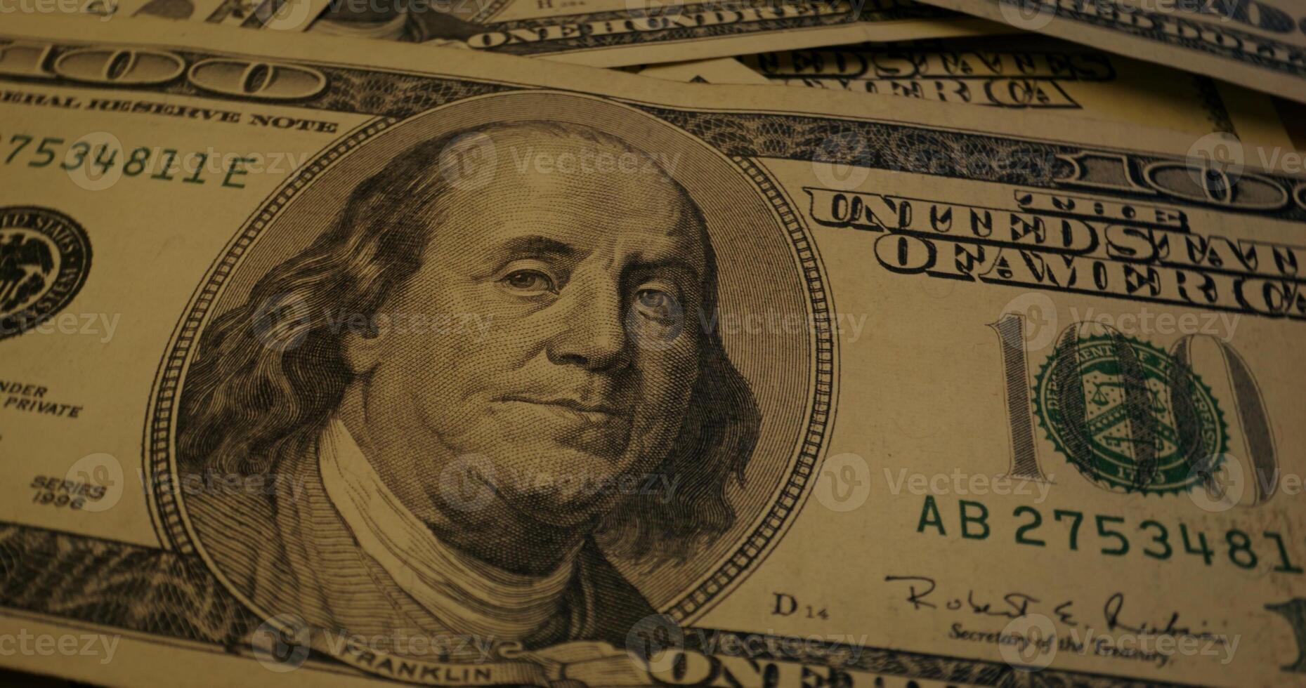 Hundred dollar bills are scattered on the table. Overview of the details of paper money - Hundred photo