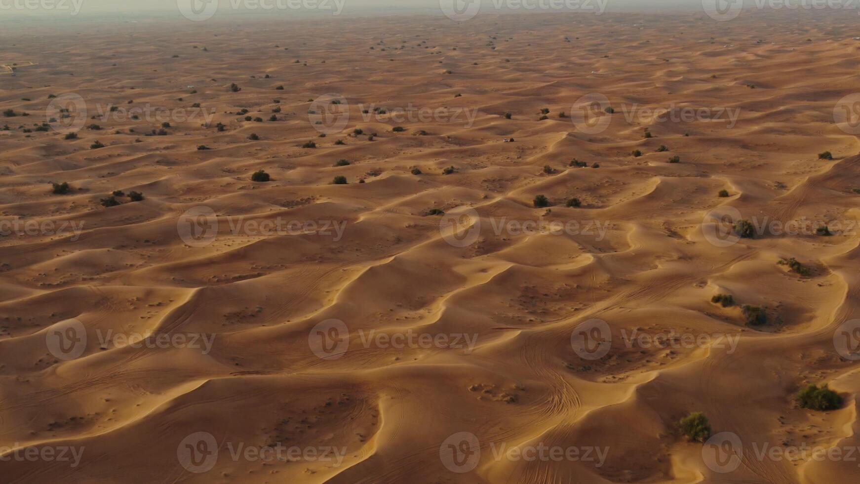 A bird's-eye view from a drone of sand dunes with traces of cars engaged in off-road driving - driving photo