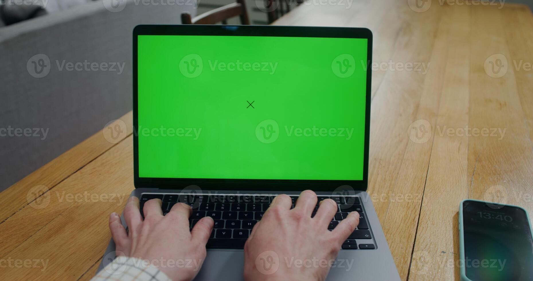 Close-up of a woman's hands while she typing on a laptop with a green screen. Front view of the screen. Copy space, mockup - mockup photo