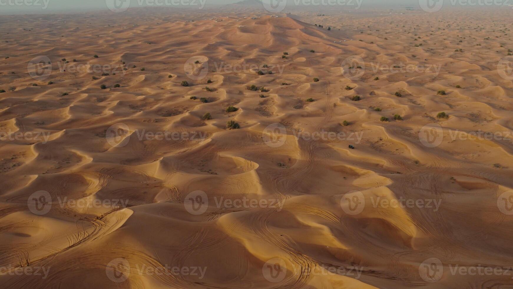 A bird's-eye view from a drone of sand dunes with traces of cars engaged in off-road driving photo