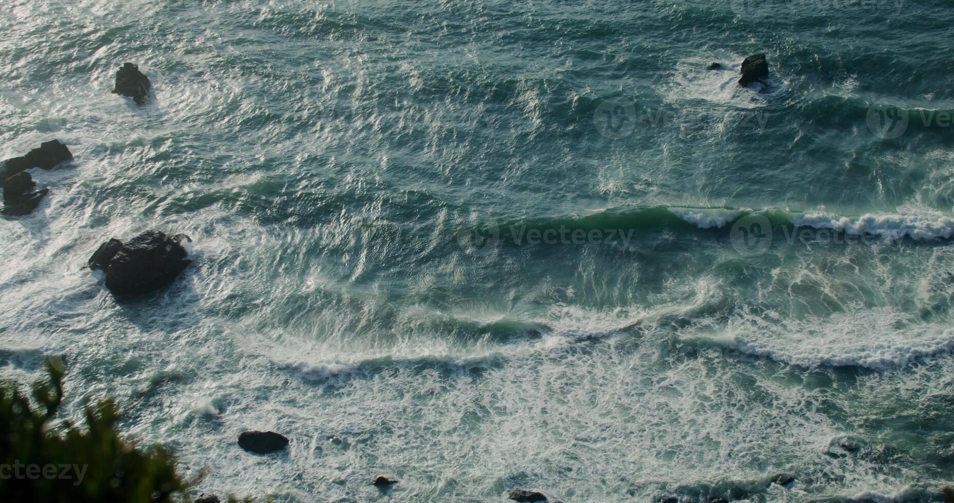 Top view of the rocky seashore, foamy waves beating against rocks, reef in shallow water - against photo