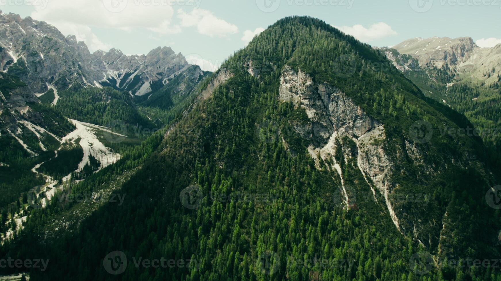 Rocky mountain peak, overgrown with dense spruce forest, bird's-eye view from a drone, high-altitude valley photo