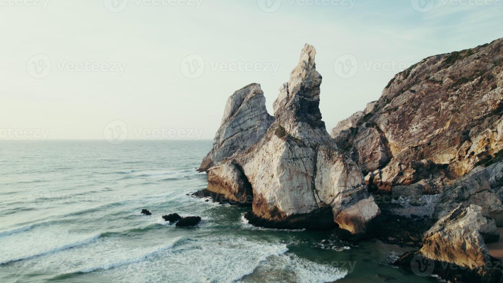 Rocks sticking out of the water on the seashore, drone view from the sea photo