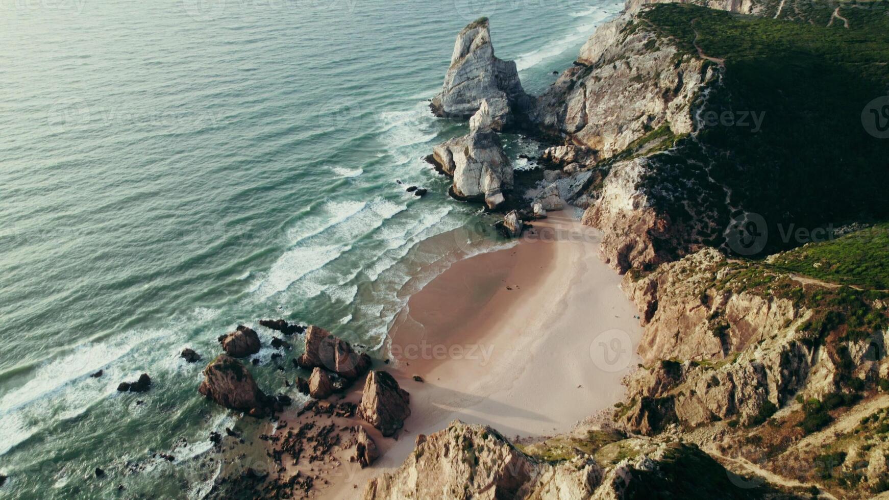 Bird's-eye view of the sea coastline with a sandy beach and stone cliffs photo