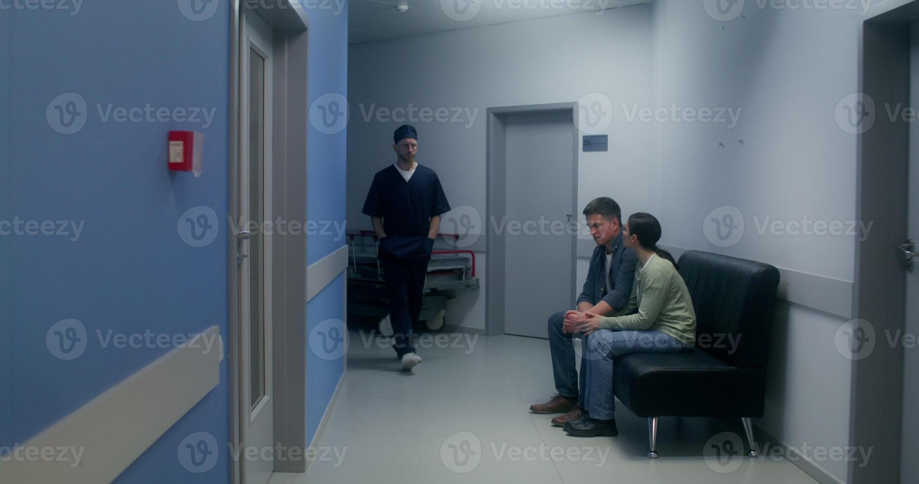 The doctor informs the relatives of the disappointing result of the operation, they cry, standing hugging in the hospital corridor - disappointing photo