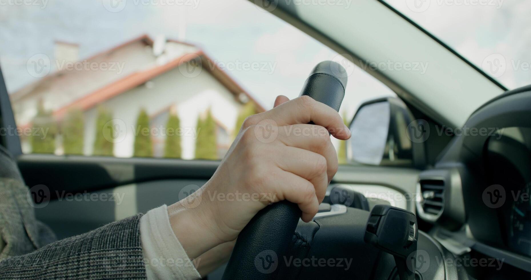 A business woman drives a car around the city on a sunny day, close-up of her hands on the steering wheel, an unrecognizable person - around photo