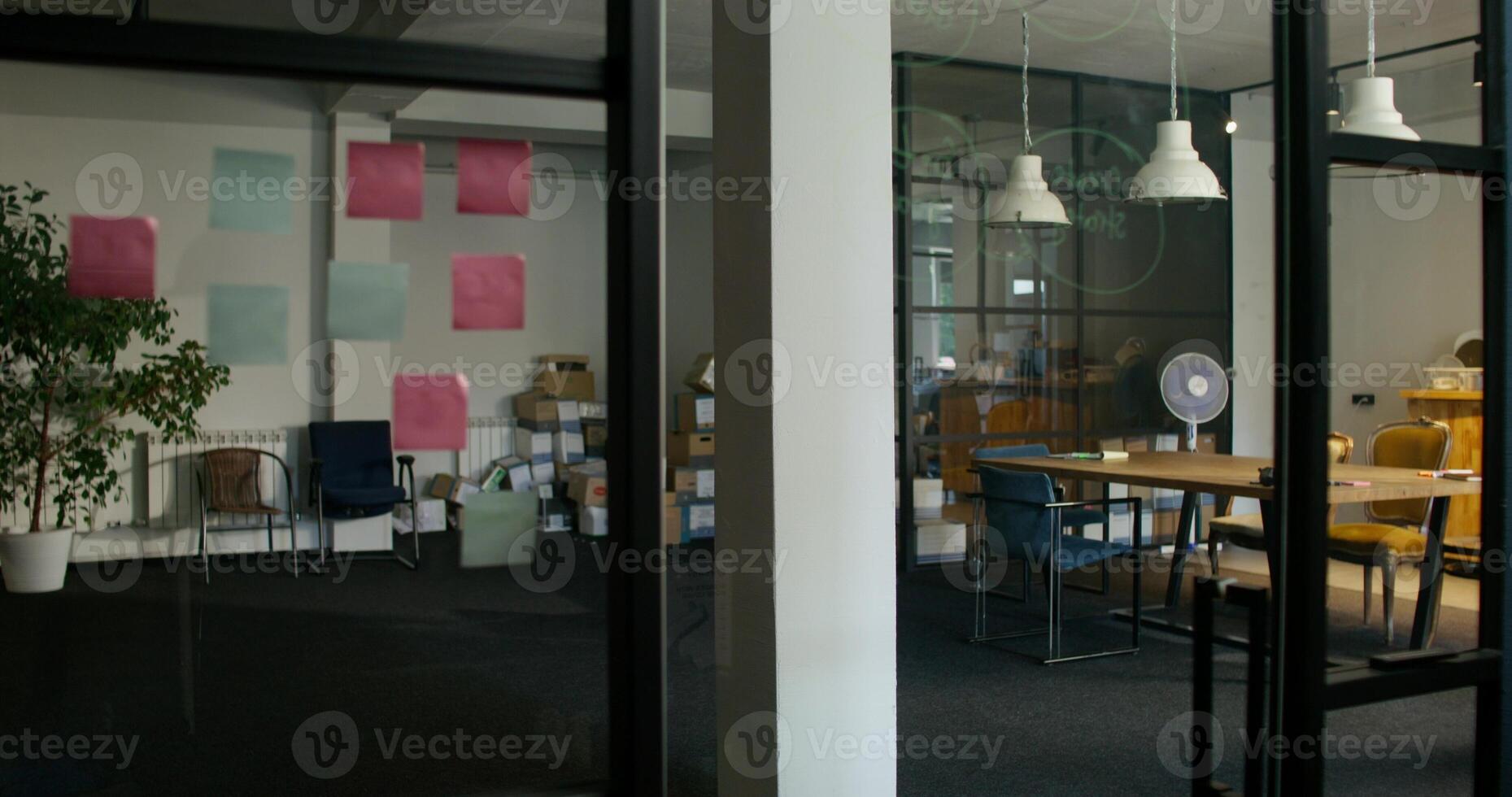 General view of a modern office. Empty boxes are lying near the wall. Two women are talking as they pass by. Daylight - talking photo