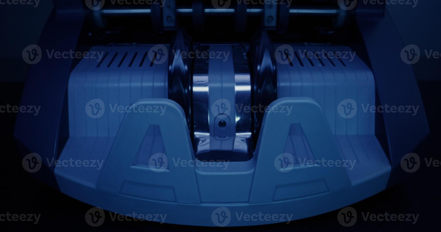 The calculating machine counts a stack of dollar bills on a dark background, front view, close-up photo