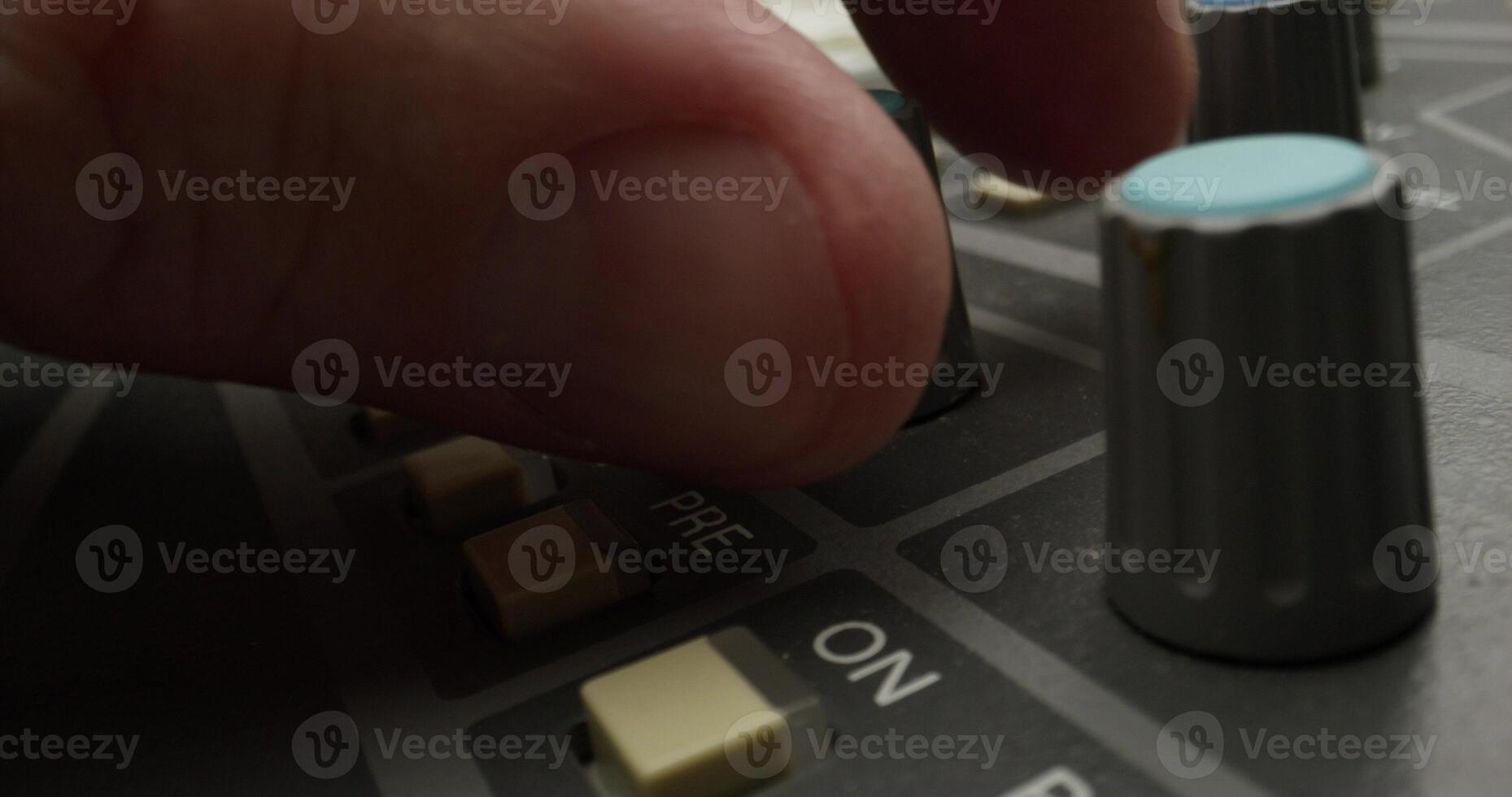 A man controls a mixing console while recording audio in the studio. Close-up of his hand, an unrecognizable person - recording photo