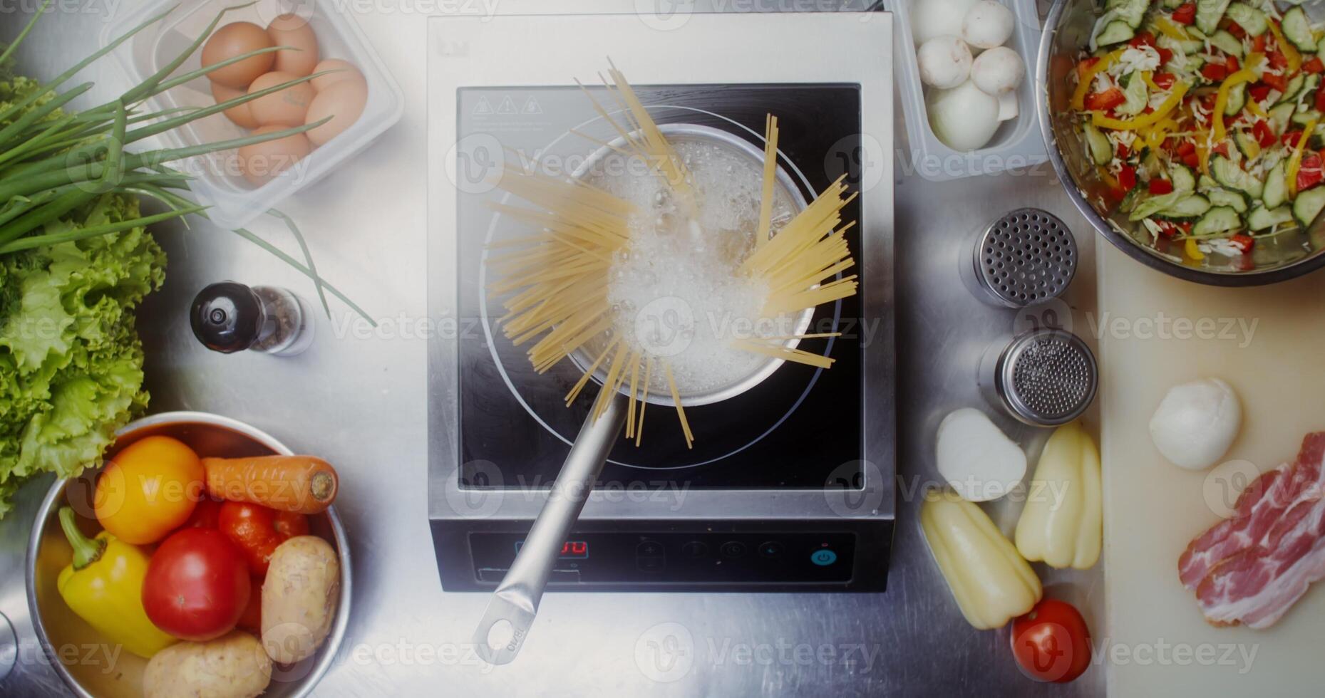 Pasta in a pot of water on the stove, top view, no people photo