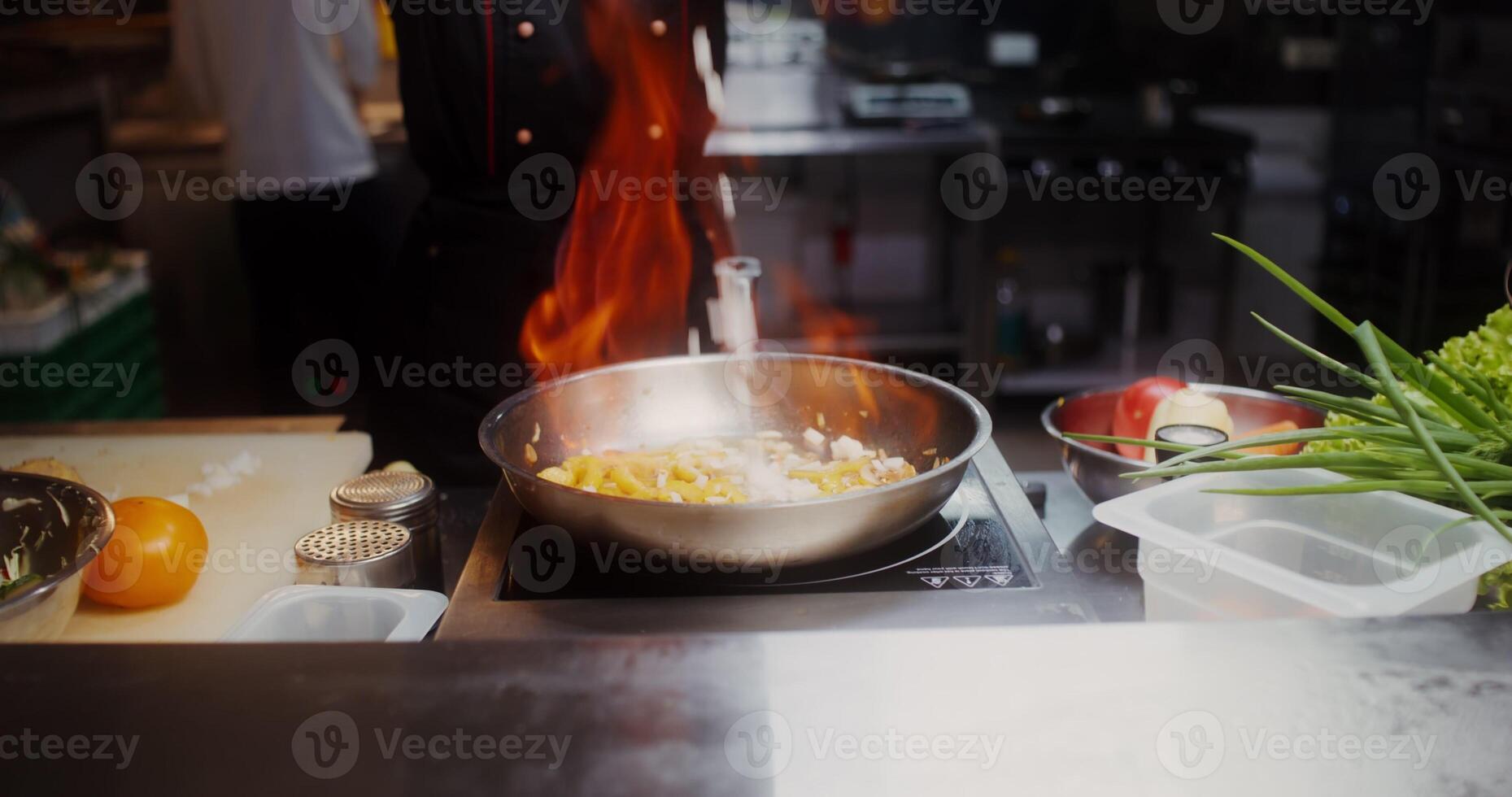 A woman in disposable black gloves, mixing the contents of a frying pan with fire, close photo