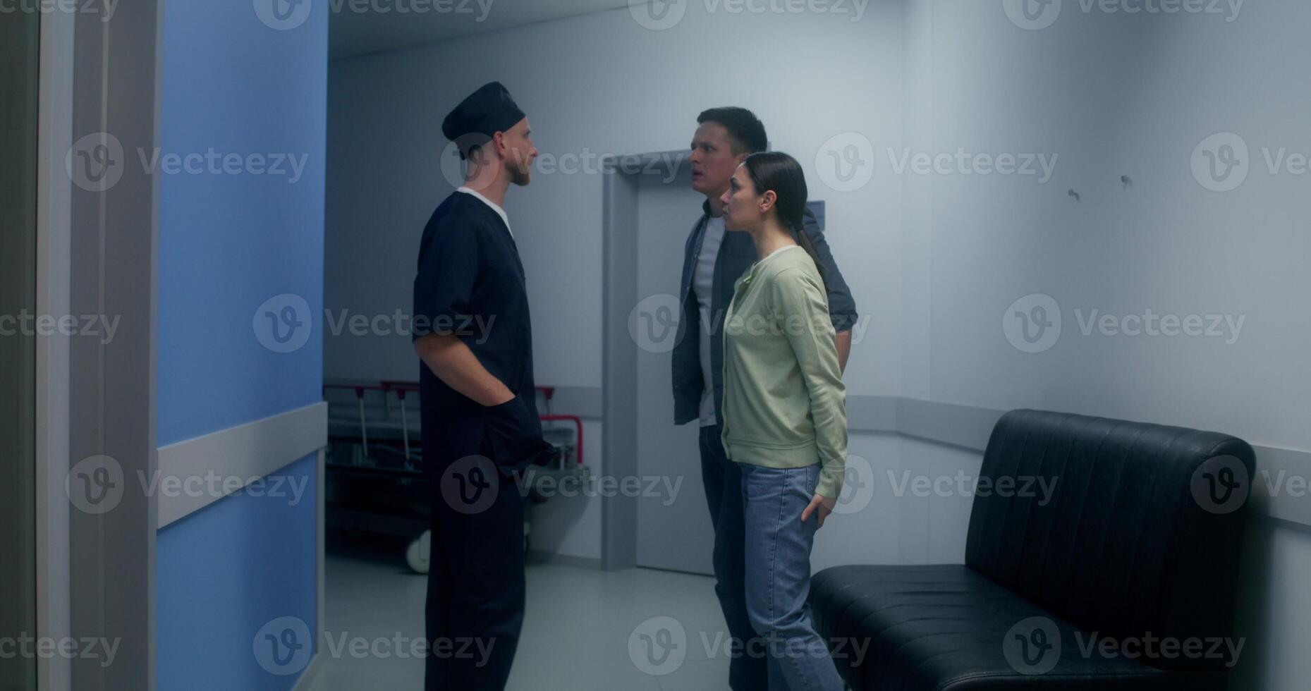 The doctor informs the relatives of the disappointing result of the operation, they cry, standing hugging in the hospital corridor photo