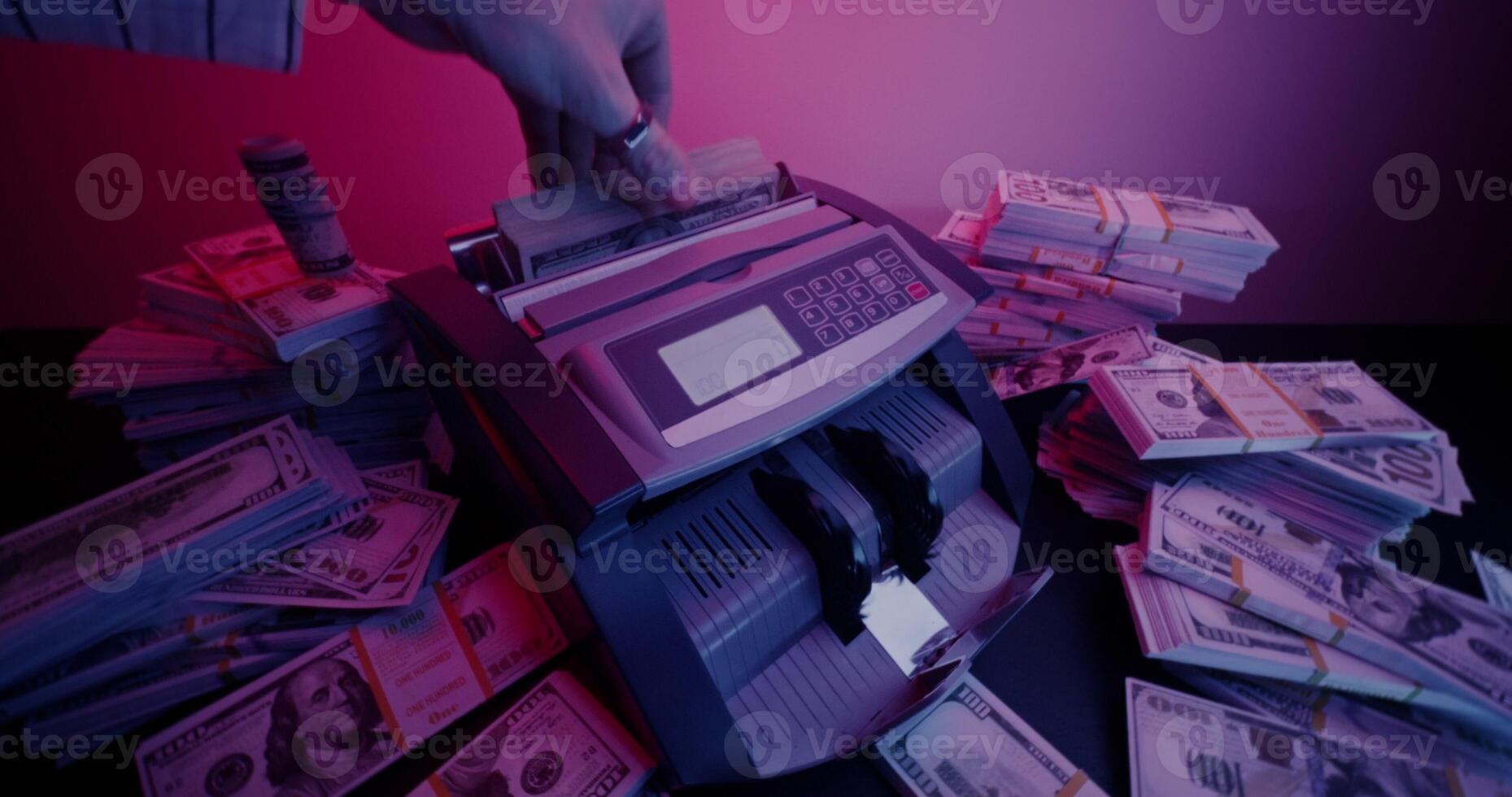 The calculating machine counts a stack of dollar bills. Bundles of money are lying around on the table - counts photo