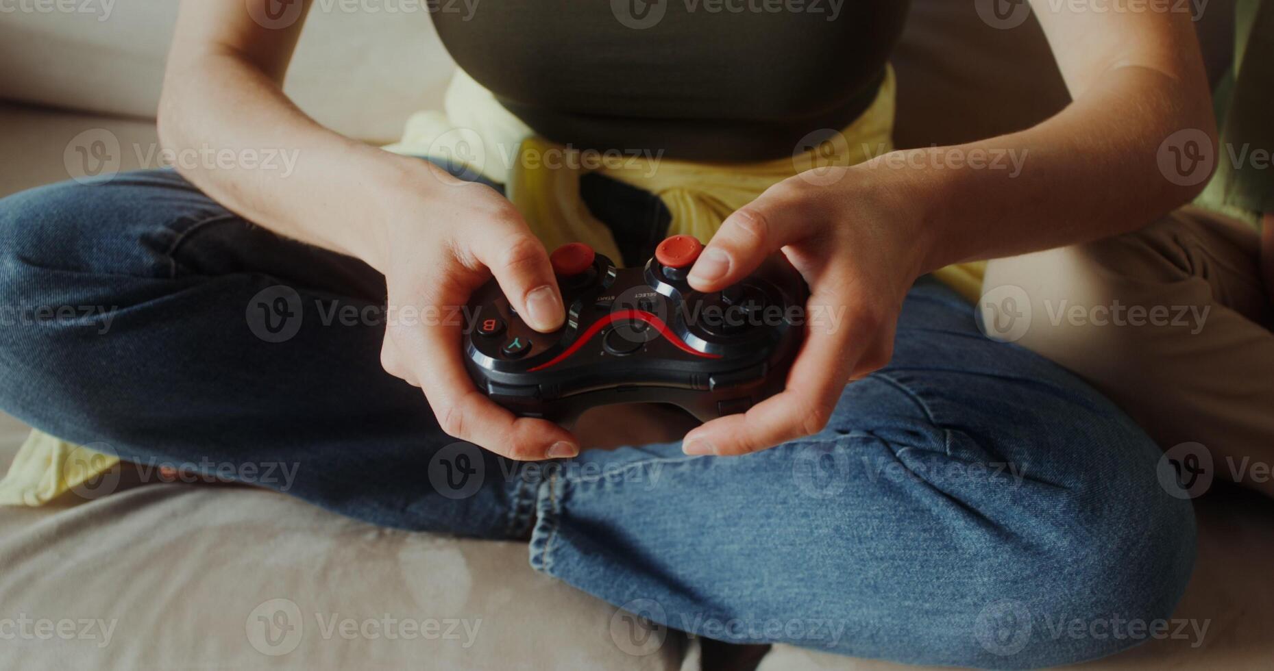 Mom and son playing games using joysticks sitting on the couch, close-up of hands, no faces photo