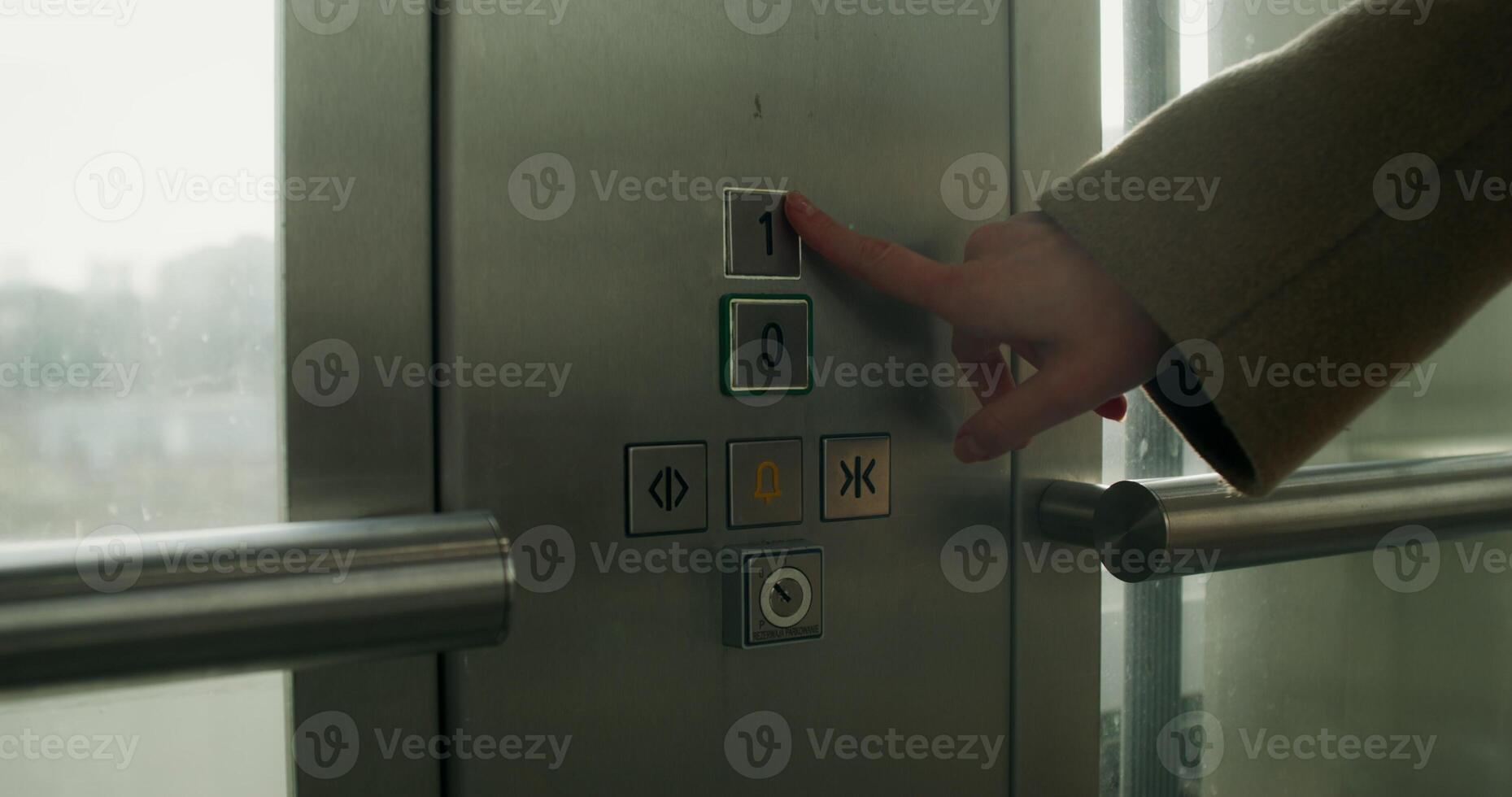A woman presses the floor selection button in an elevator, close-up of her hand, an unrecognizable person - unrecognizable photo