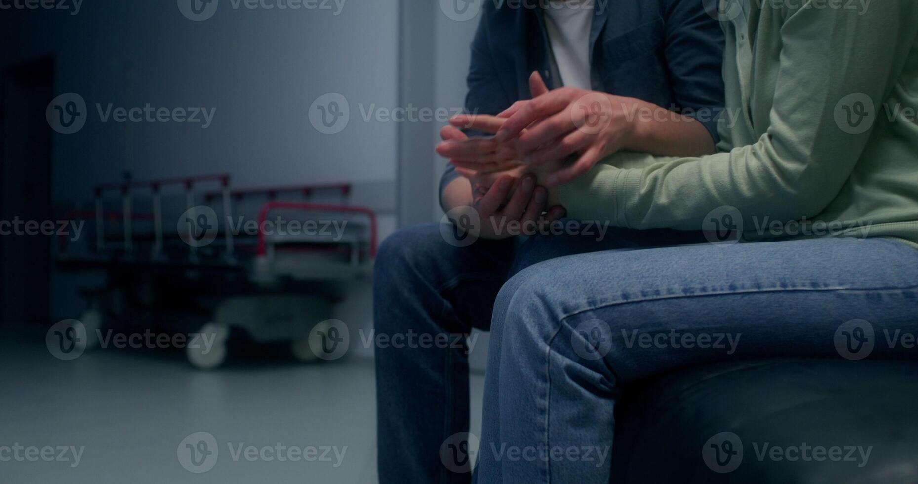 Concerned patient's relatives are waiting sitting on the couch in the hospital corridor - waiting photo