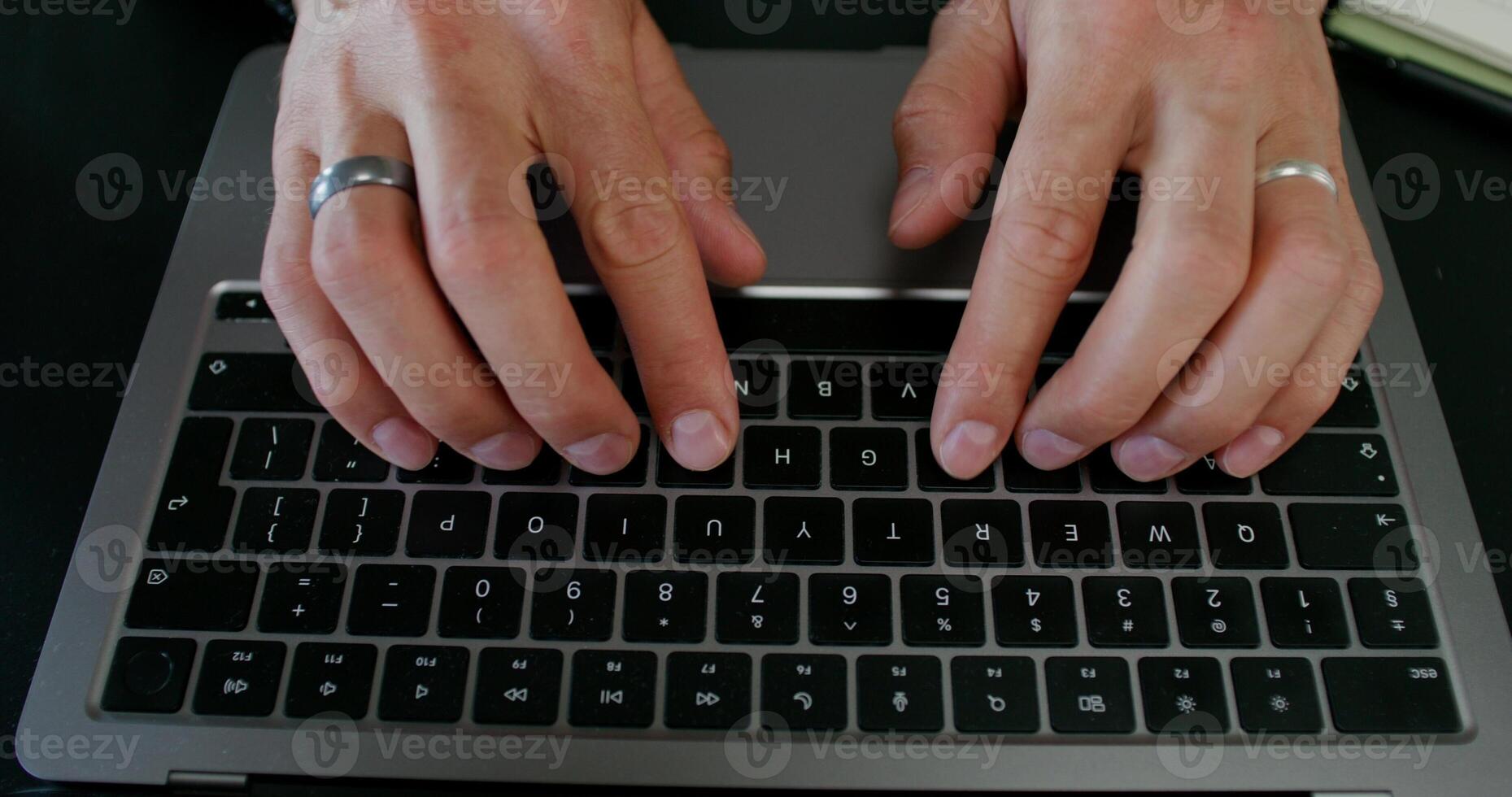 A man typing on a laptop keyboard sitting at his desk. Close-up of his hands, an unrecognizable person. Daylight - keyboard photo